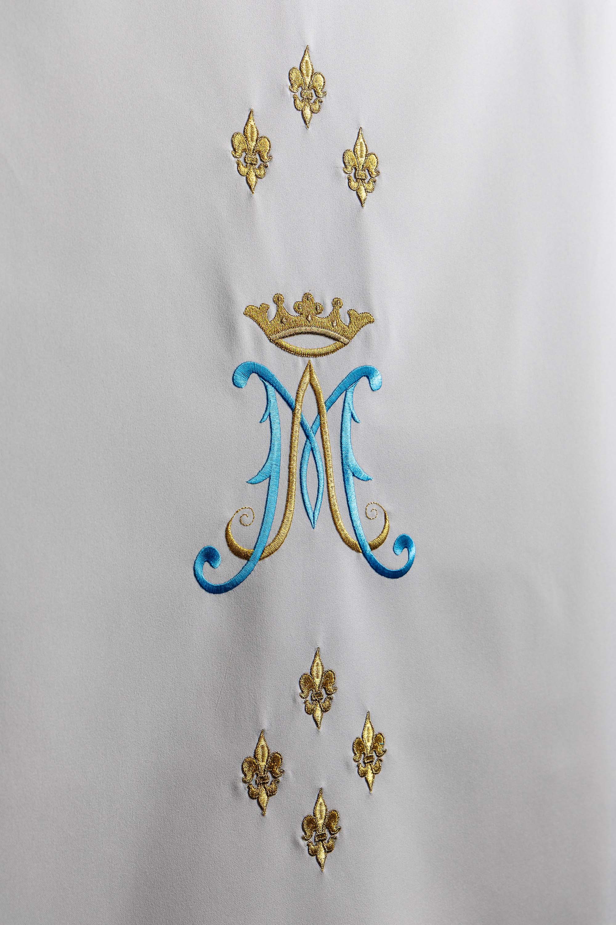 White lectern cover embroidered with a white Marian motif