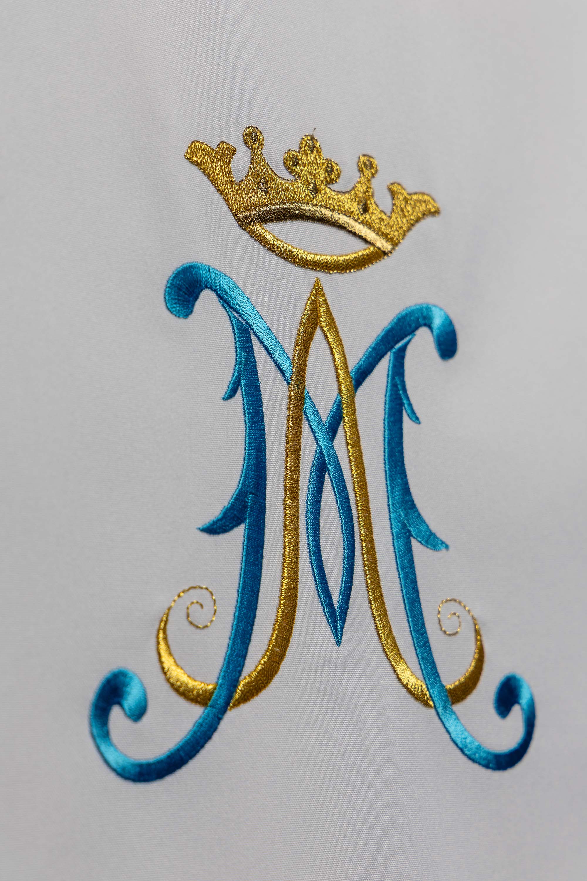 White lectern cover embroidered with a white Marian motif