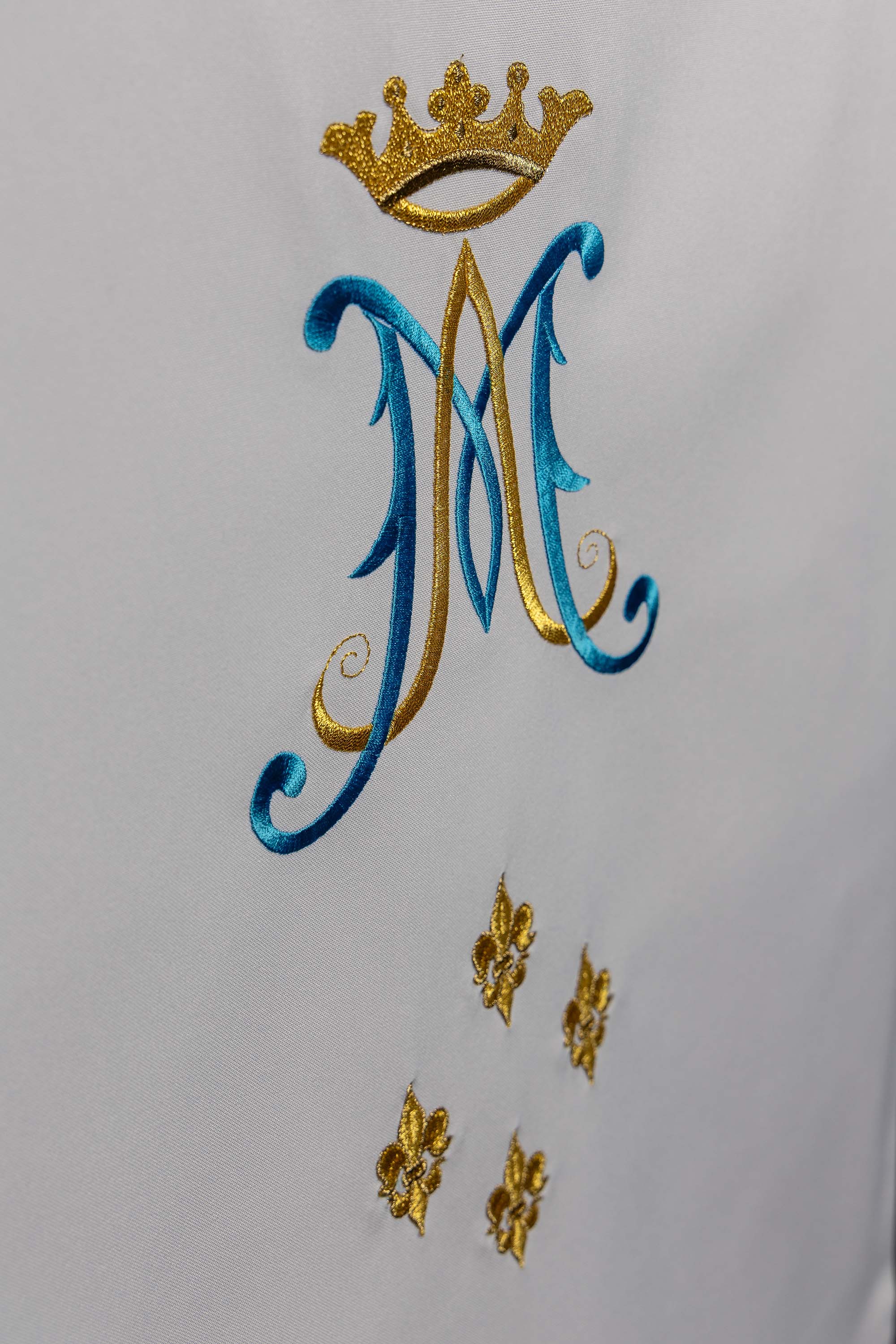 White lectern cover embroidered with a white Marian motif