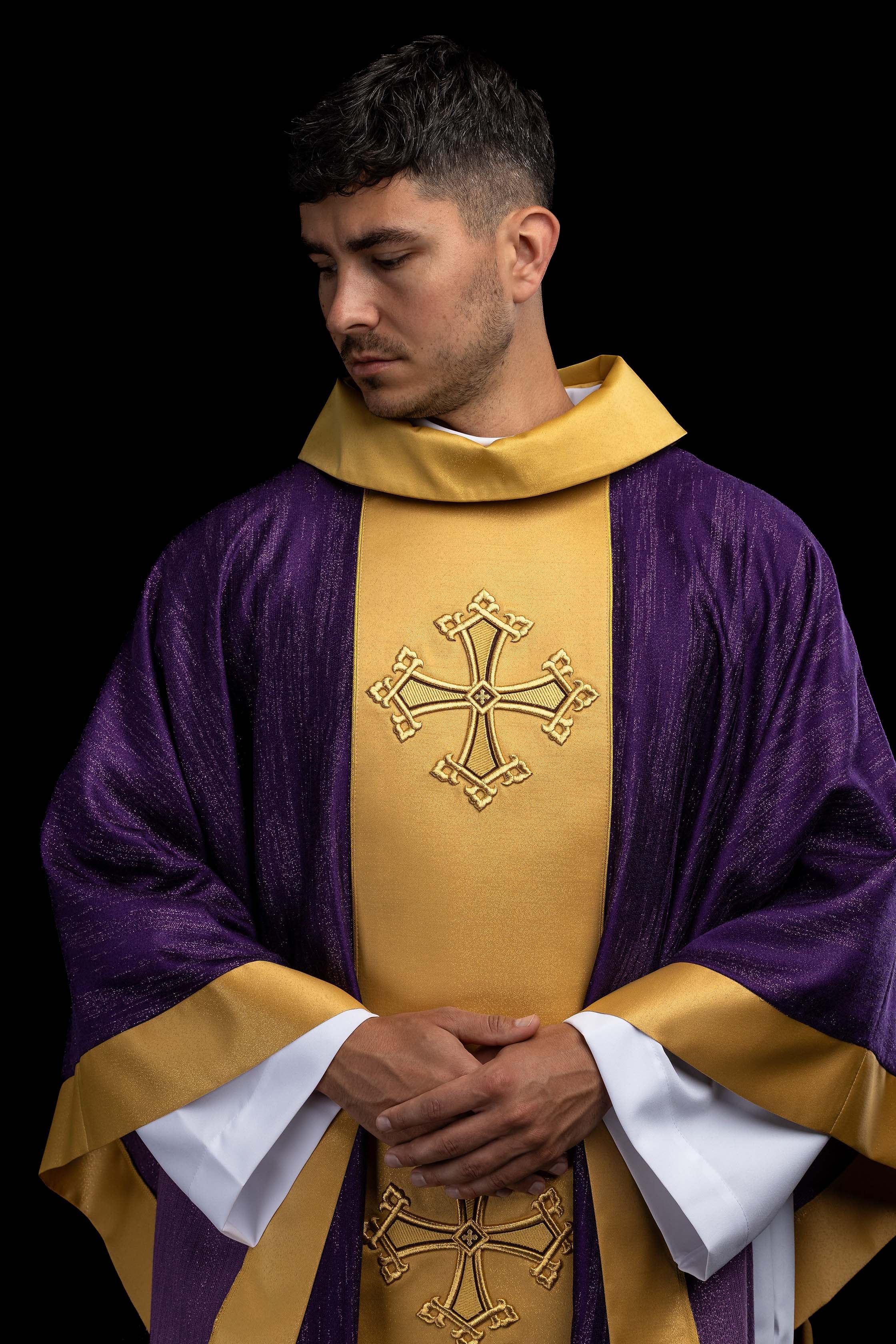 Purple chasuble with an embroidered cross motif and band on decorative fabric