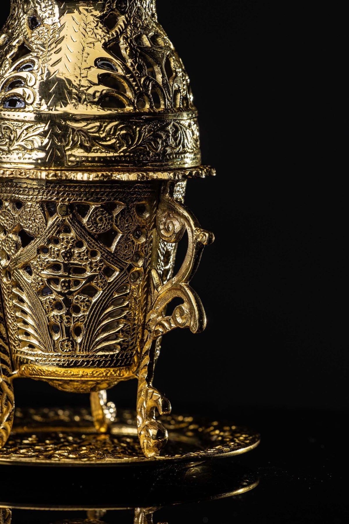 Side close-up of the Brass Incense Burner showing ornate scrollwork handle, pierced body, and leg
