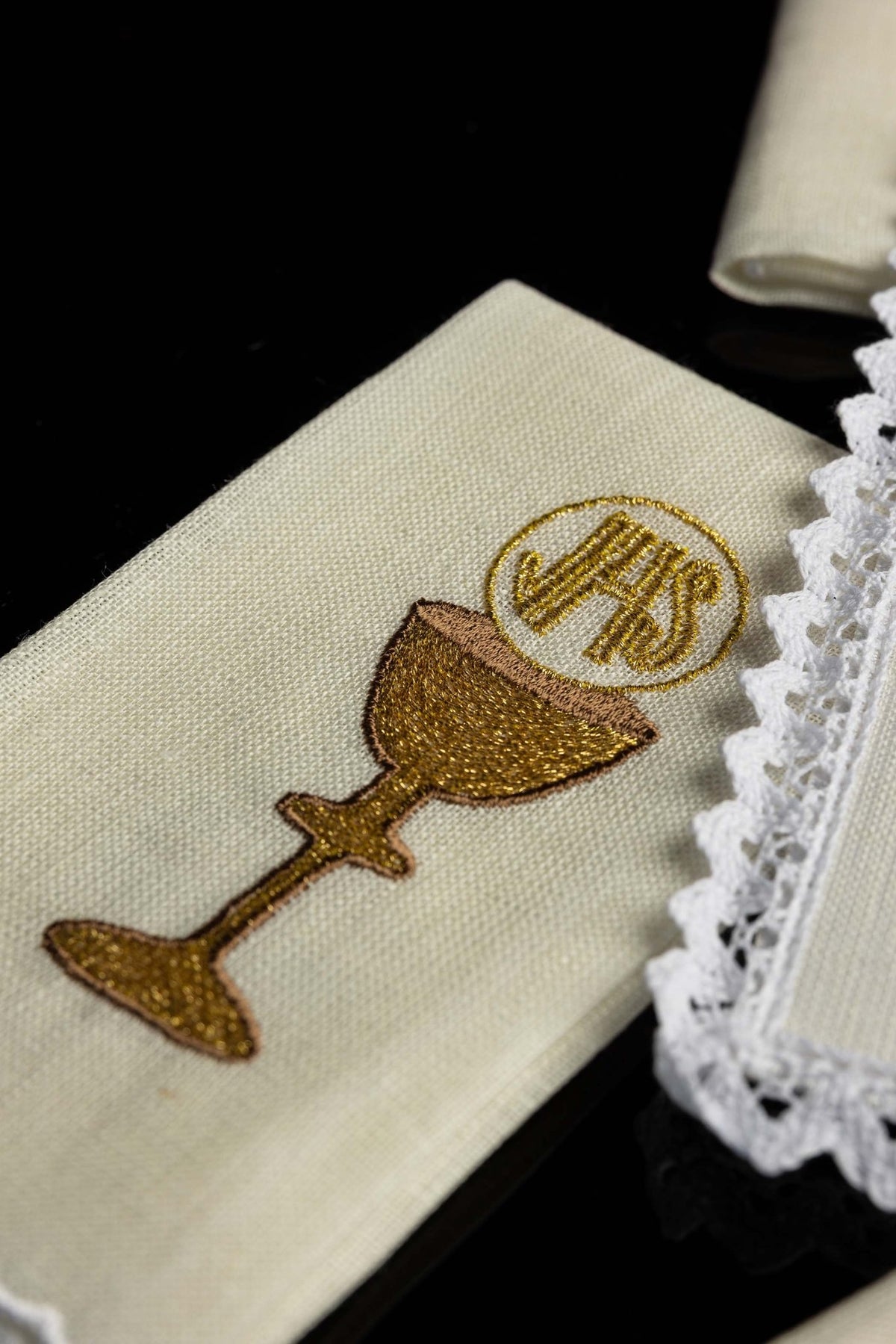 Close-up of chalice linen showing a gold embroidered chalice and Eucharistic monogram