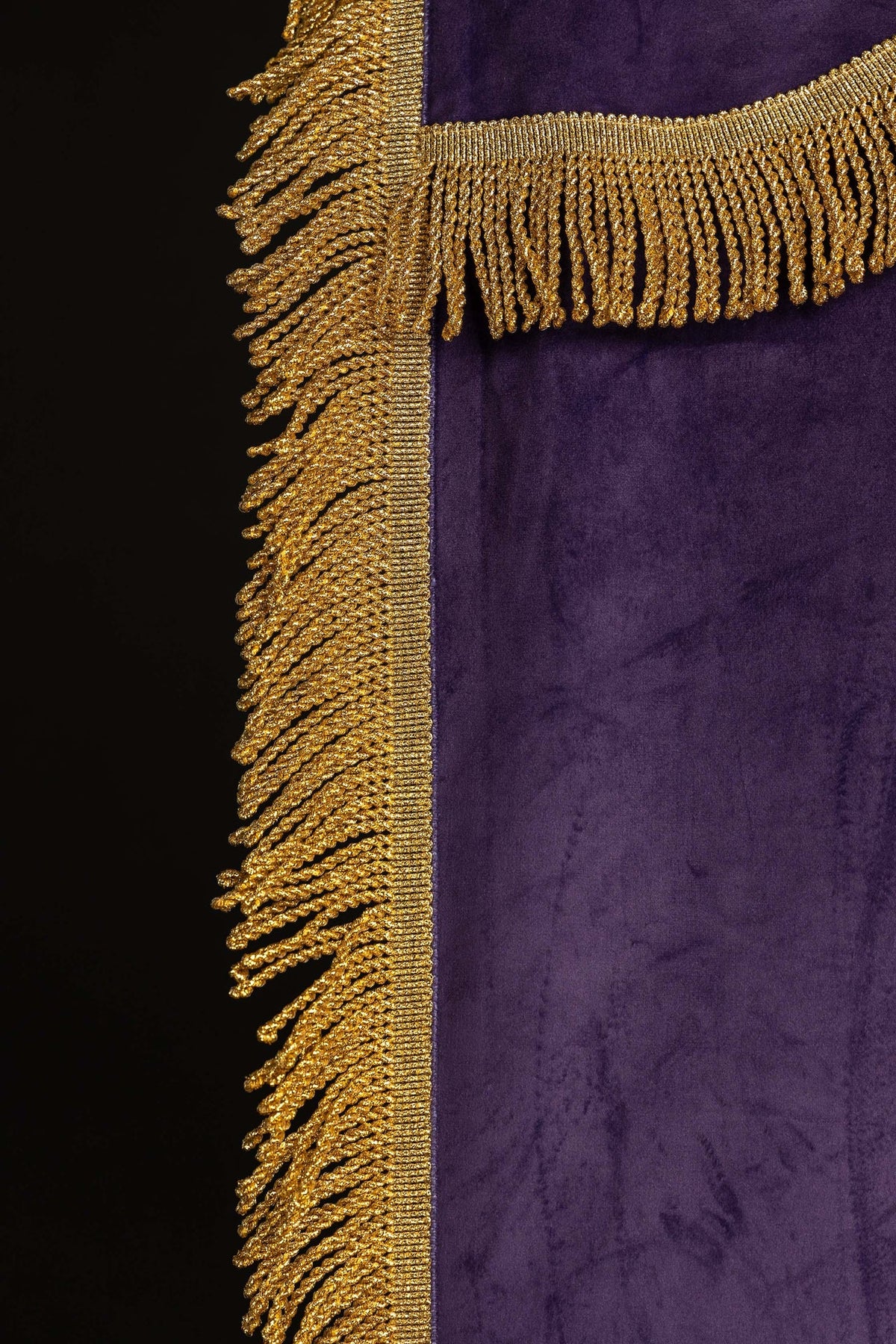 Close-up of the purple banner showing gold fringe at the side and top