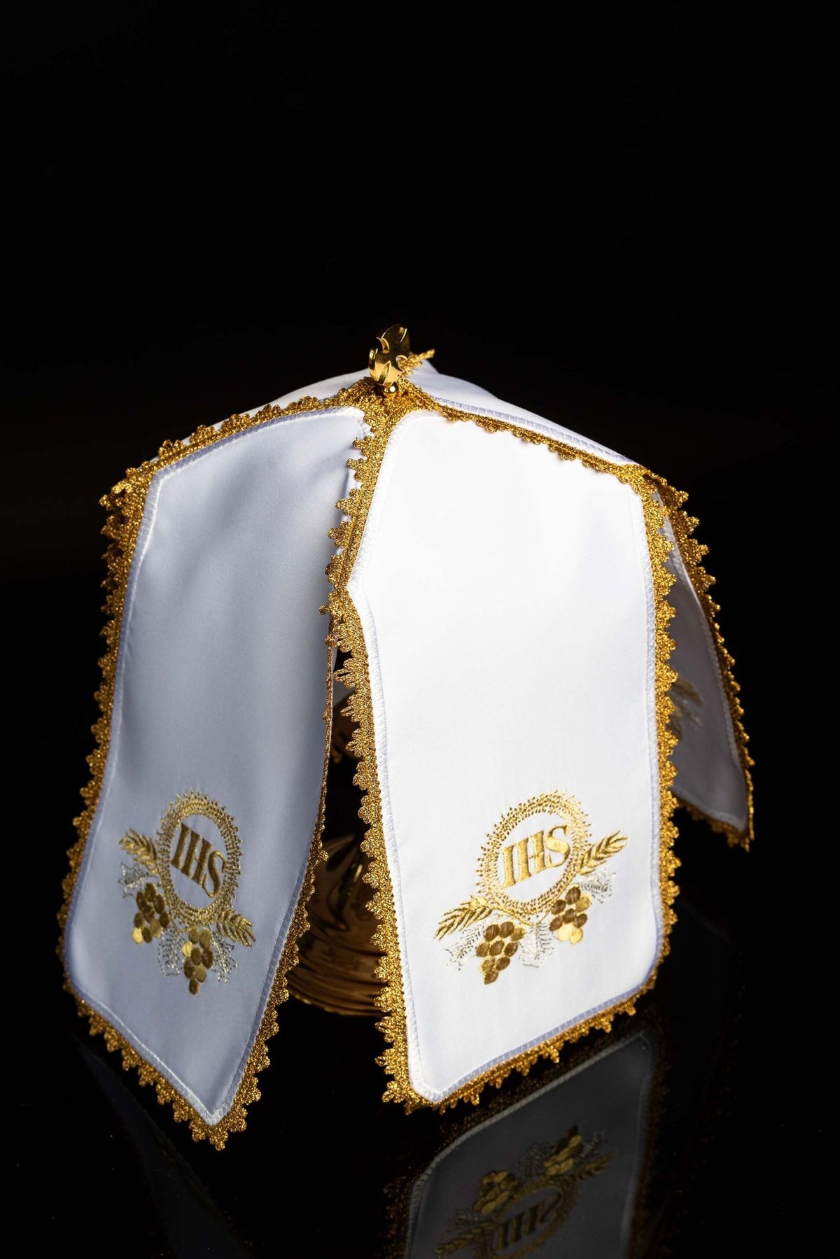 Angled view of the ciborium veil showing matching white panels, gold trim, and IHS motifs