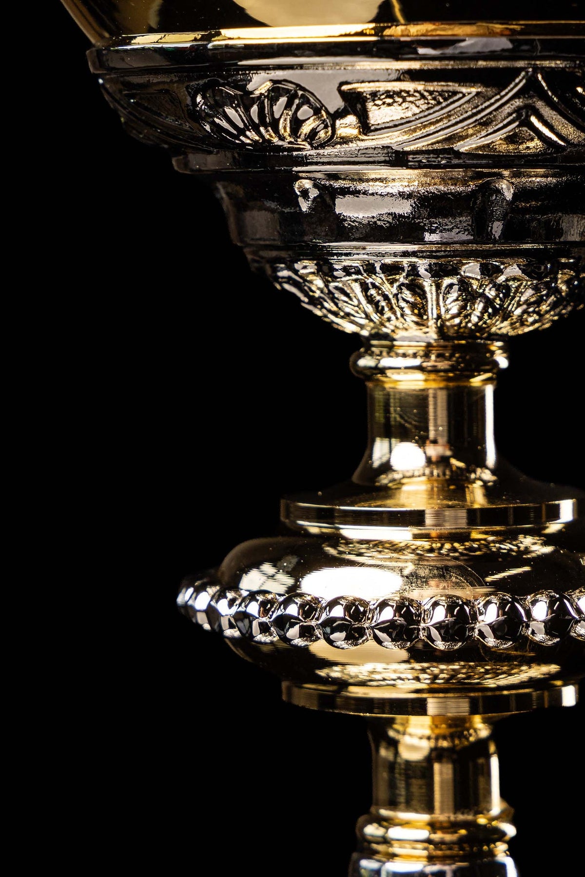 Detail view of the chalice stem and beaded foot edge in gold and silver