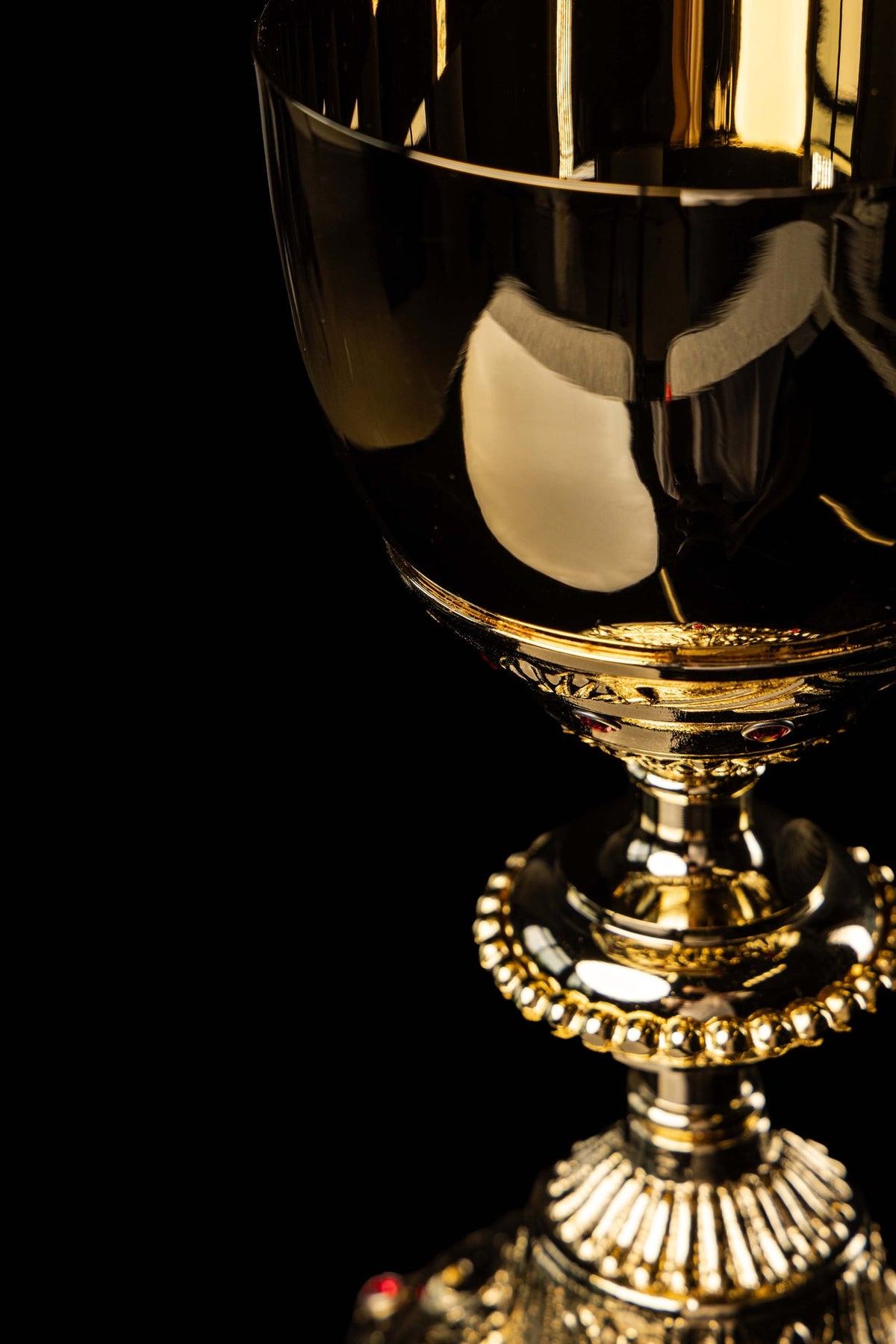 Close-up of the gold-plated chalice cup and stem with reflective finish and red accents