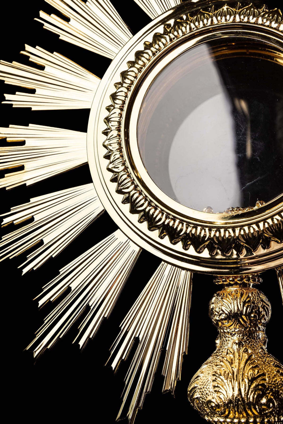 Close-up of the monstrance showing its gold-plated decorative rim and glass luna