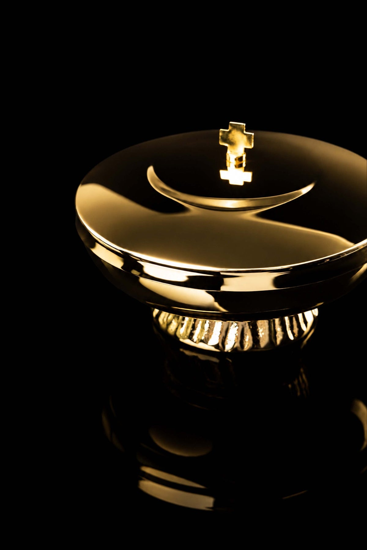 Angled view of the gold-plated brass ciborium lid, rim, cross finial, and fluted base