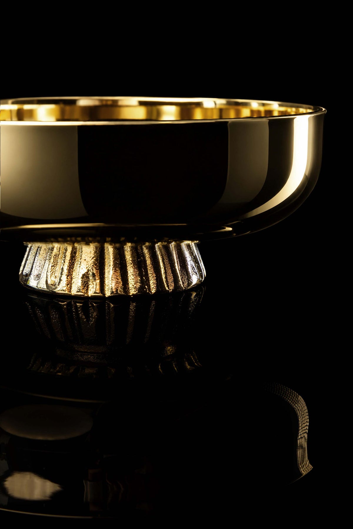 Close-up side view of the gold-plated paten with vertically grooved nodus