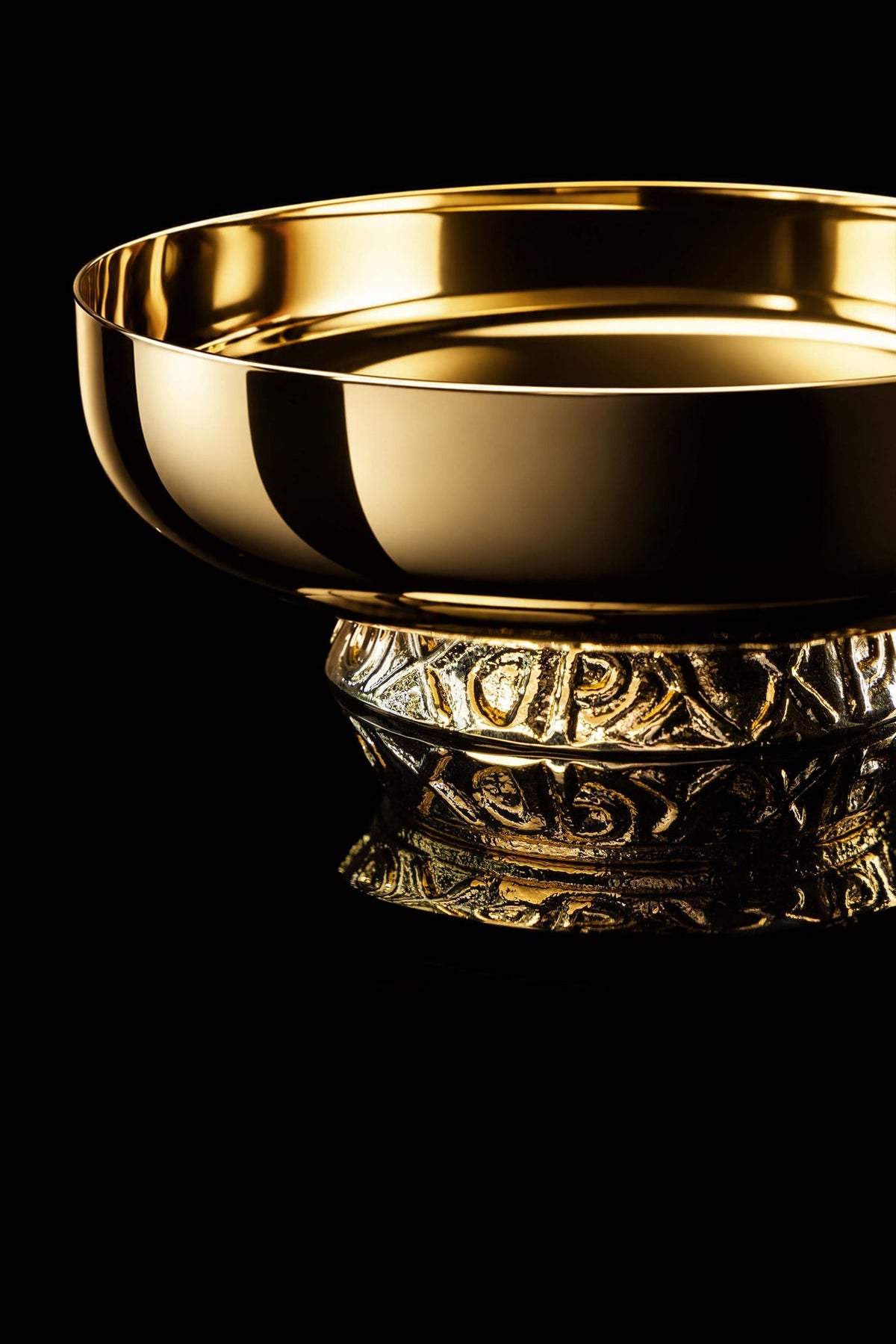 Close-up of the gold-plated paten showing the raised decorative nodus and polished rim