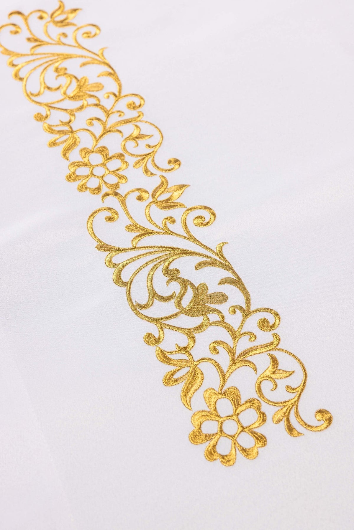 Detail of the Easter altar cloth showing repeated gold floral scroll and flower embroidery