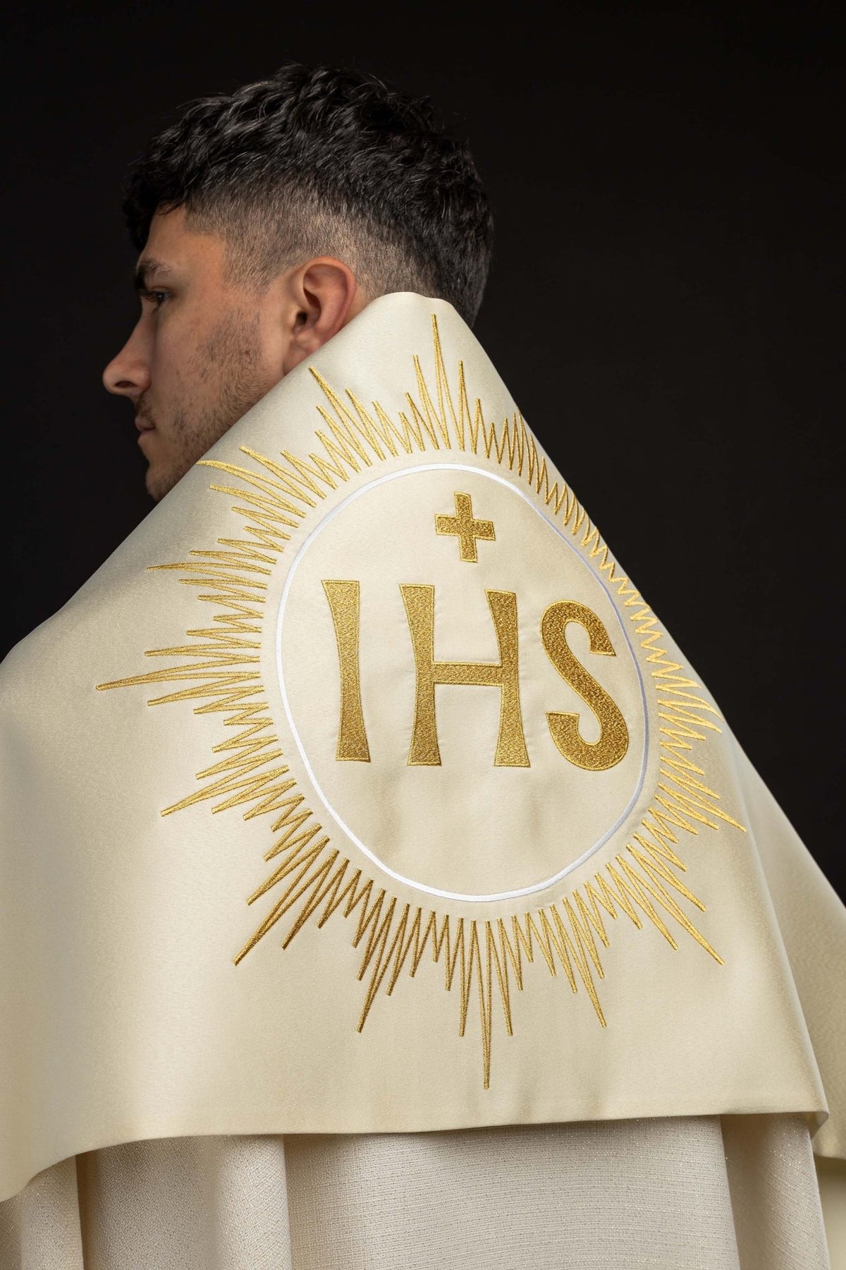 Worn back view of an Ecru Humeral Veil with Embroidered IHS Symbol and gold sunburst