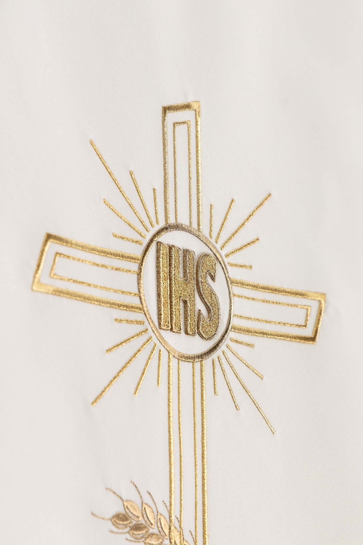 Close-up of the ecru lectern cloth showing embroidered gold cross and IHS monogram