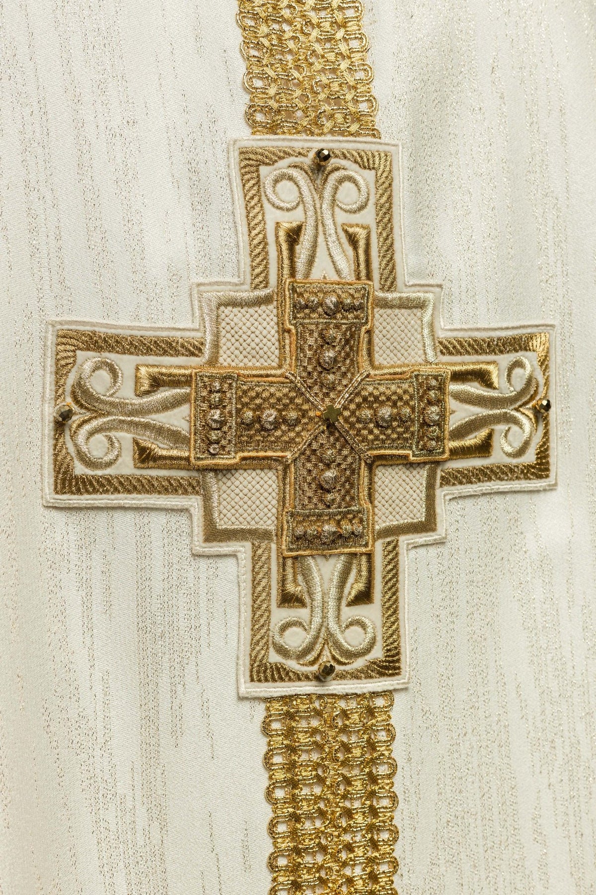 Close-up of ecru chasuble's large gold embroidered cross with stone accents