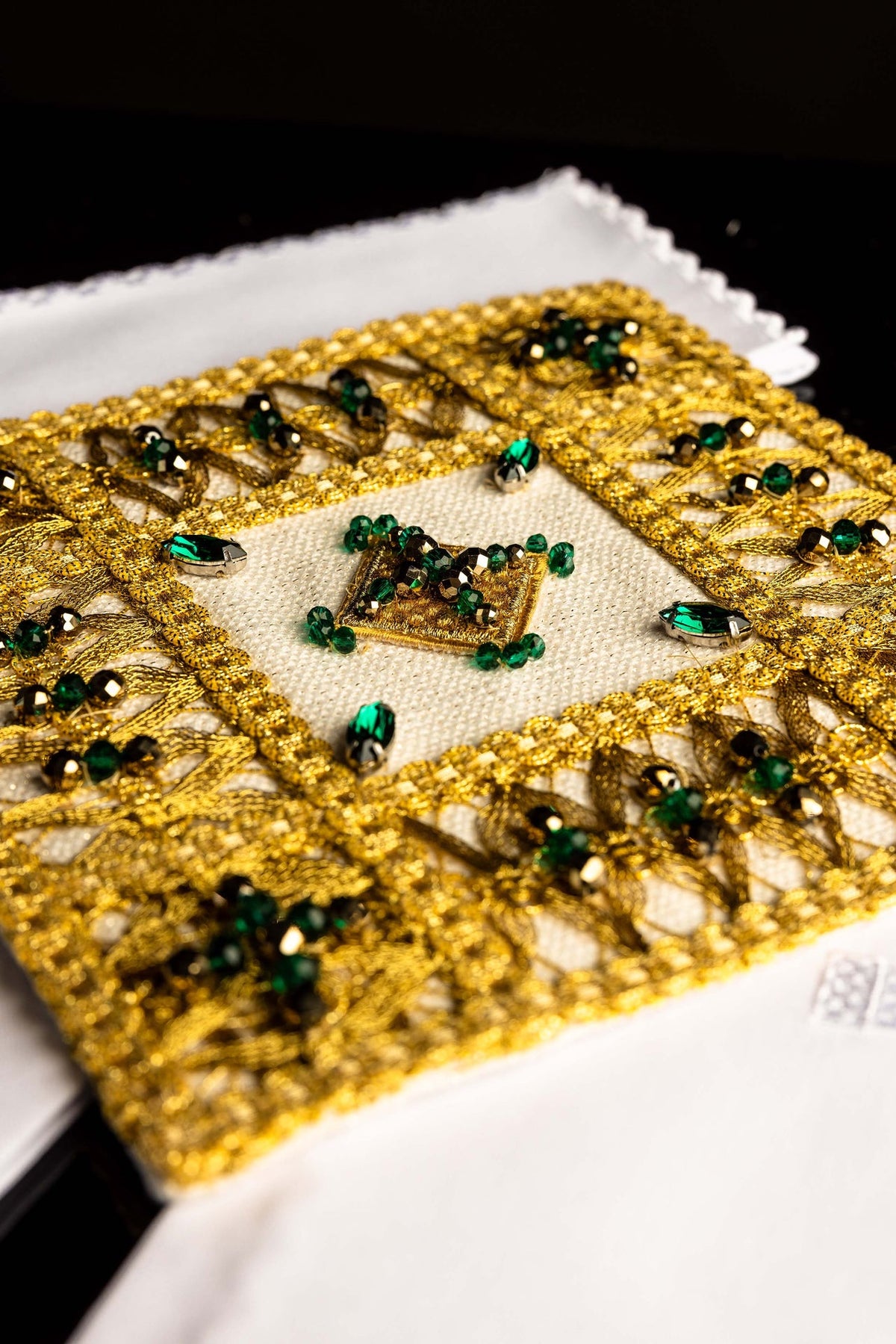 Close-up of the altar linen set's stone-embellished chalice pall with gold embroidery and green beads