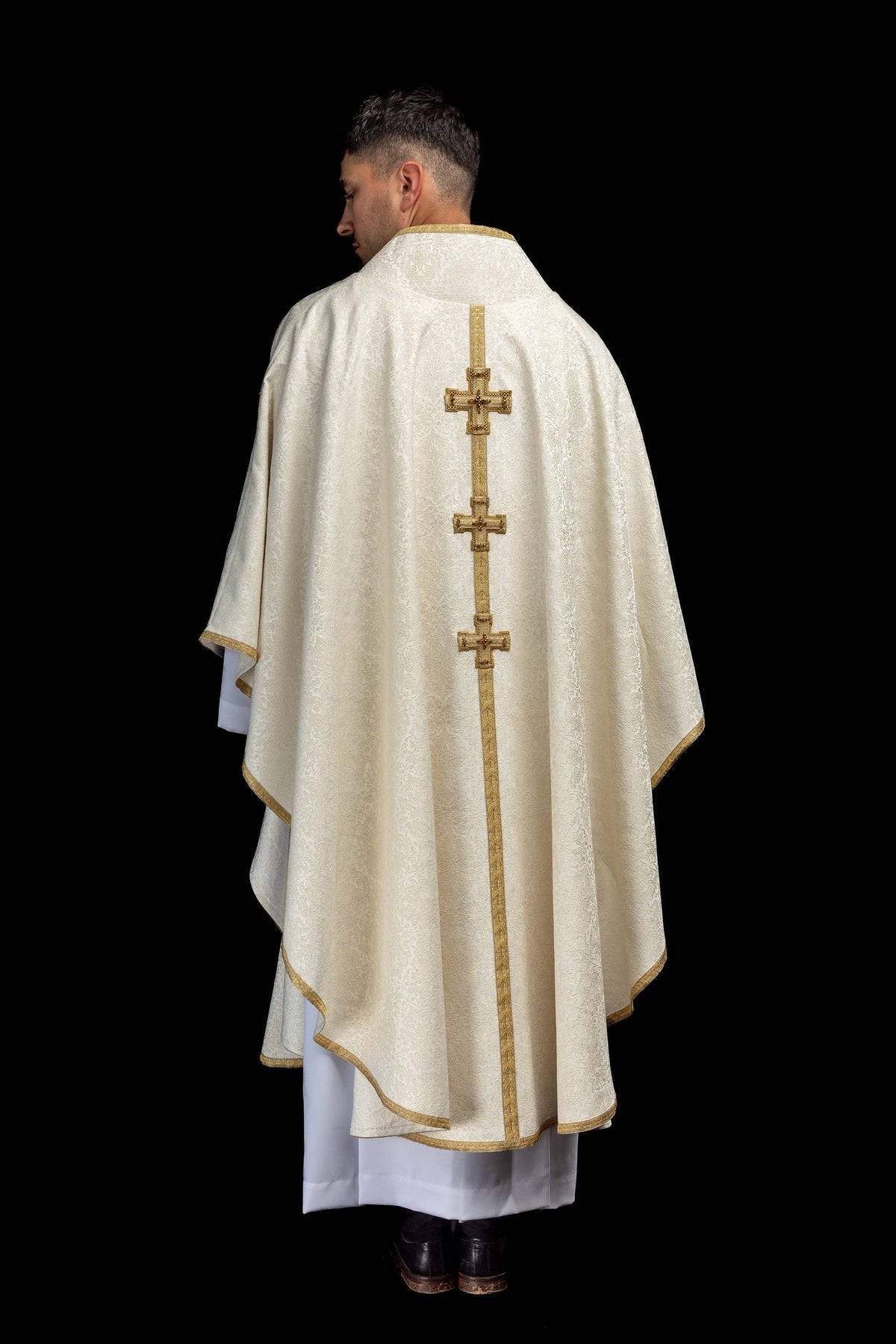 Back view of a handmade chasuble with embroidered 3D crosses and natural stones in ivory and gold