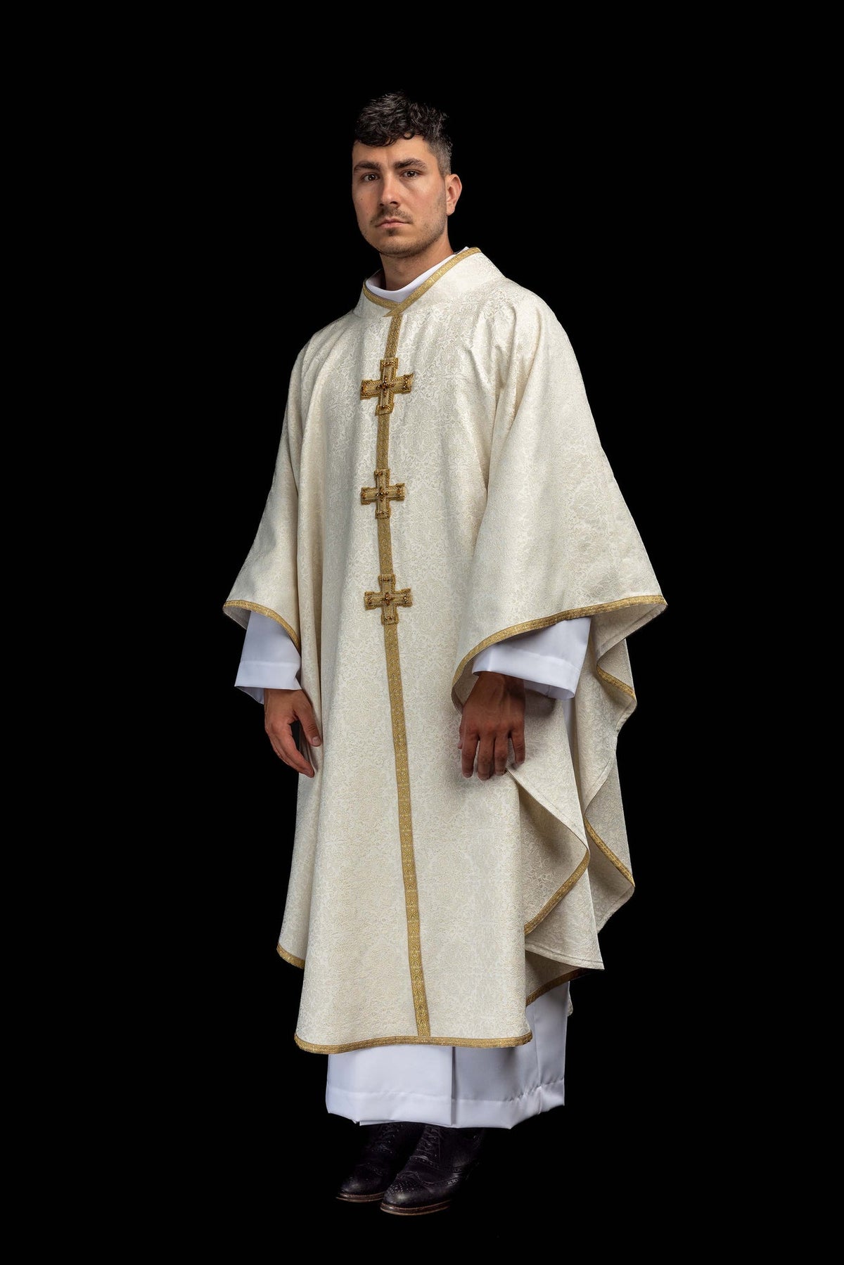 Full worn view of the chasuble with three gold crosses and patterned fabric