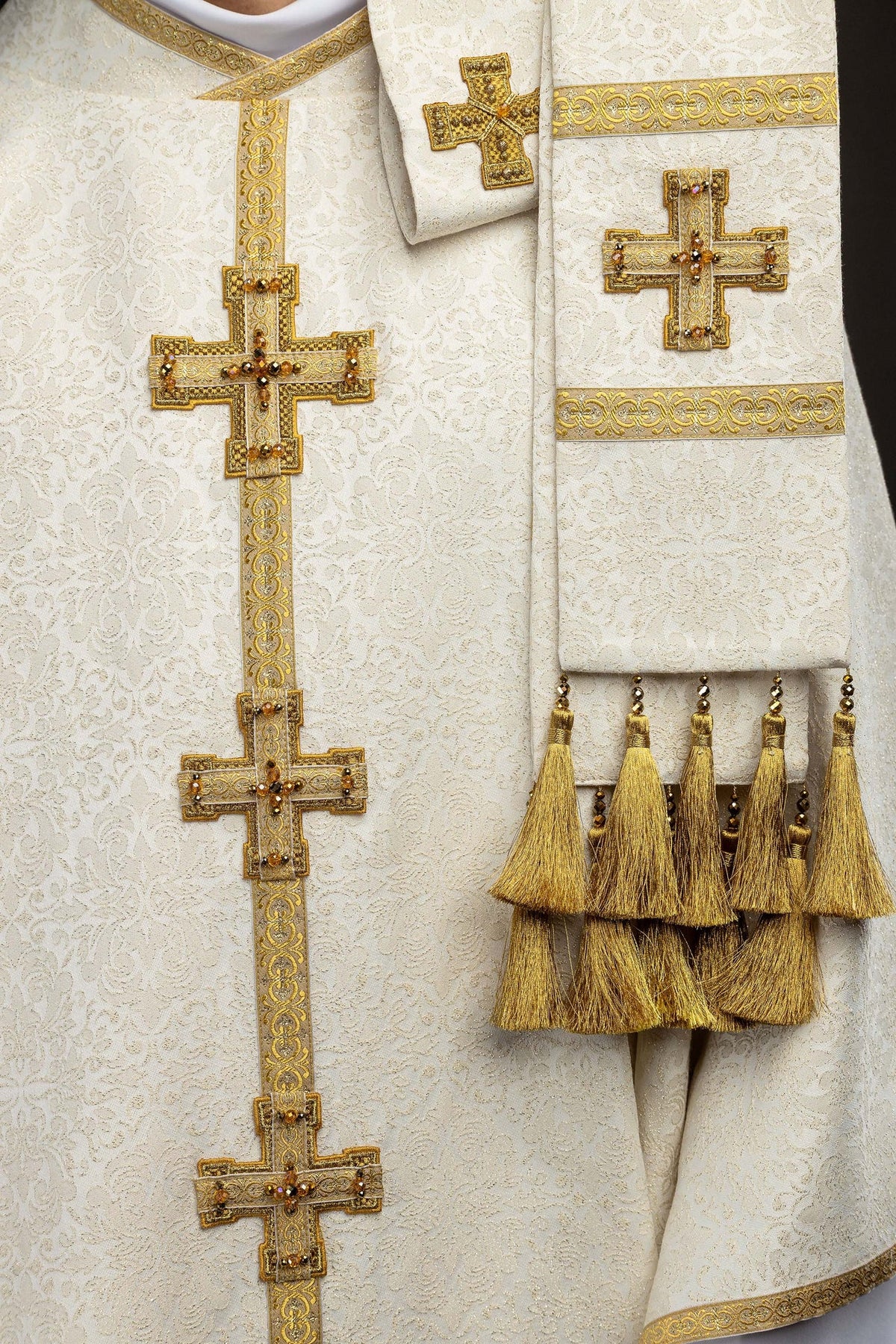 Close-up of the chasuble sleeve with gold edging and cross embroidery