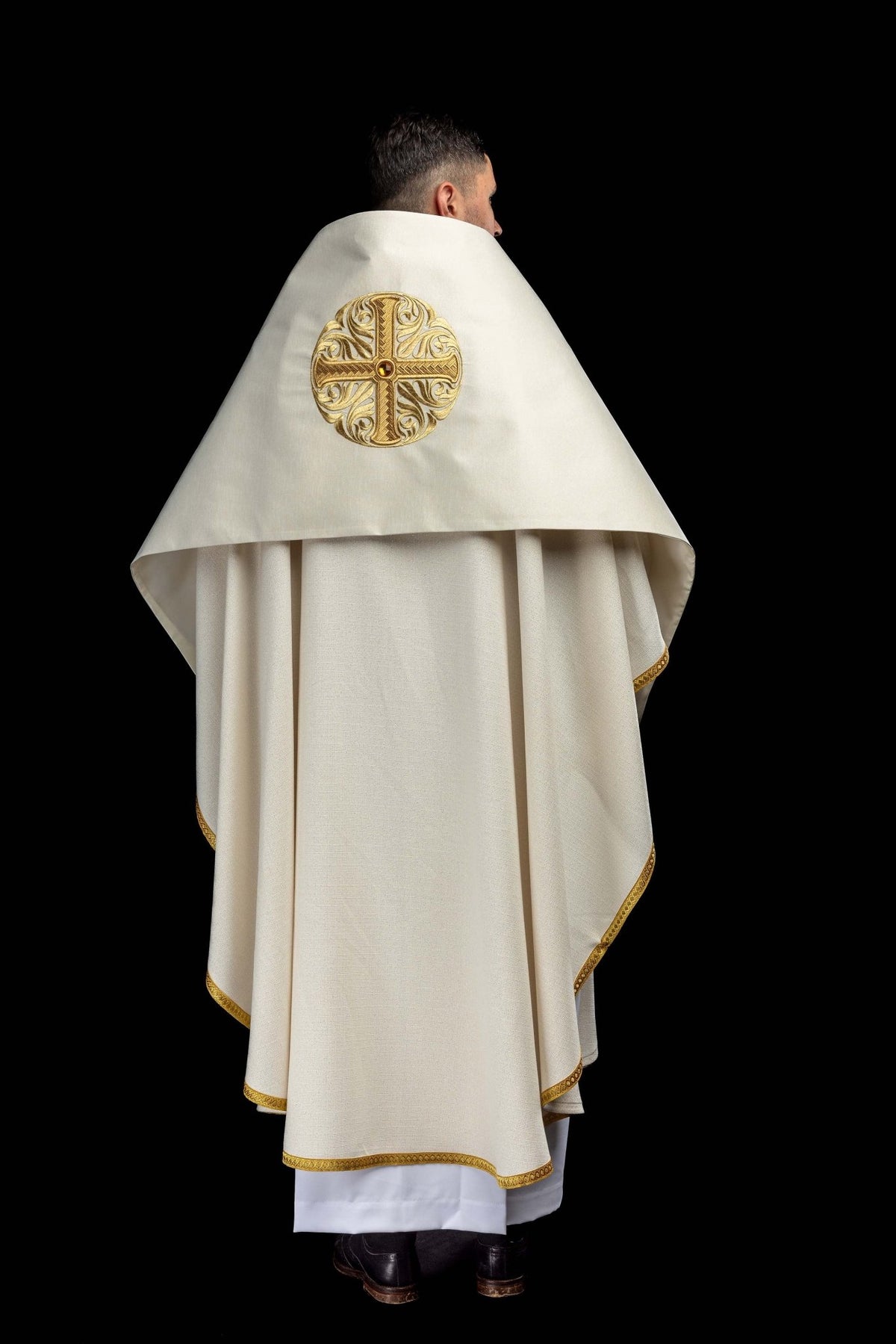 Worn back view of the humeral veil with embroidered gold cross and decorative stone