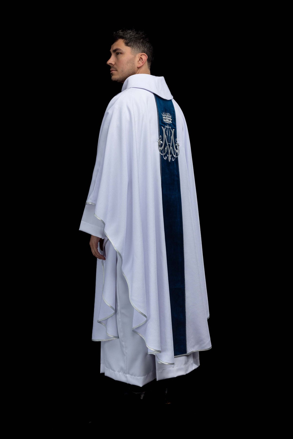 Side back view of the ecru chasuble with blue velvet orphrey and silver-edged hem