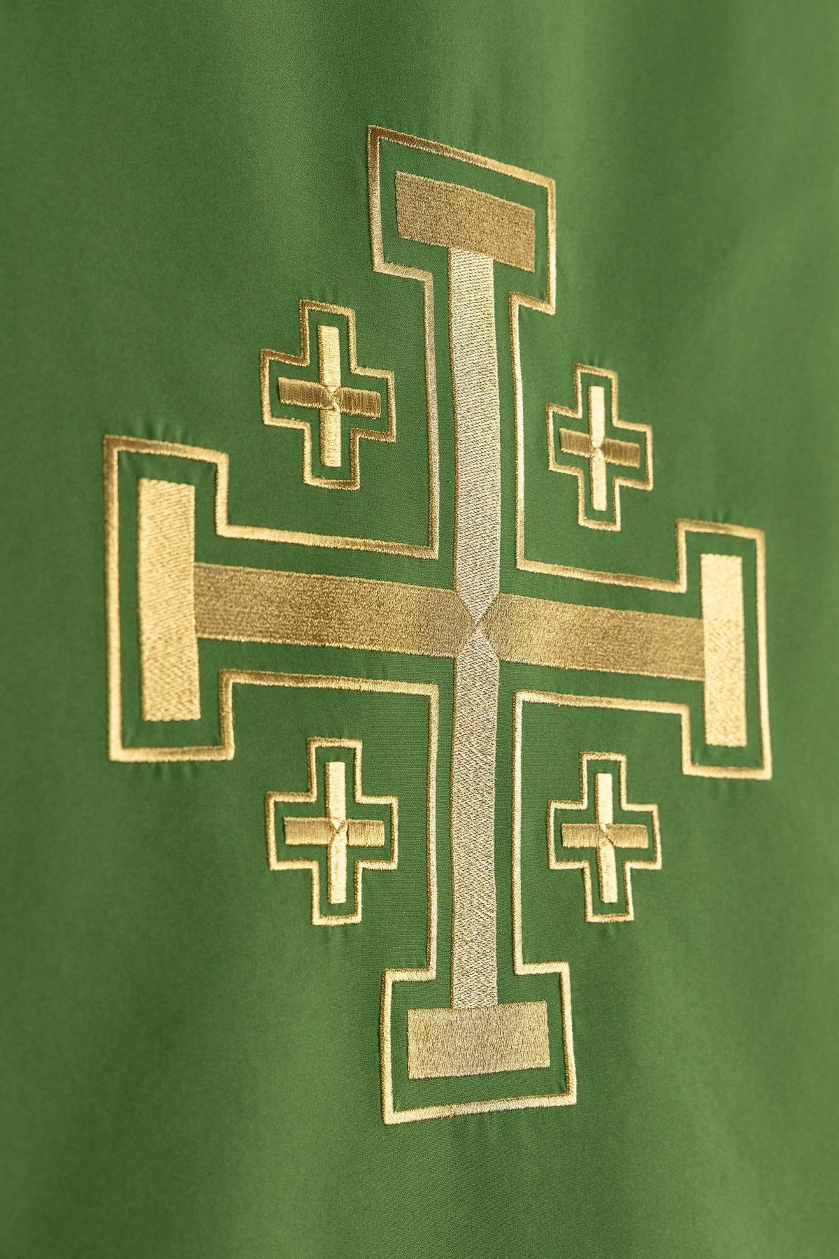 Close-up of the green church lectern cover showing gold Jerusalem cross embroidery