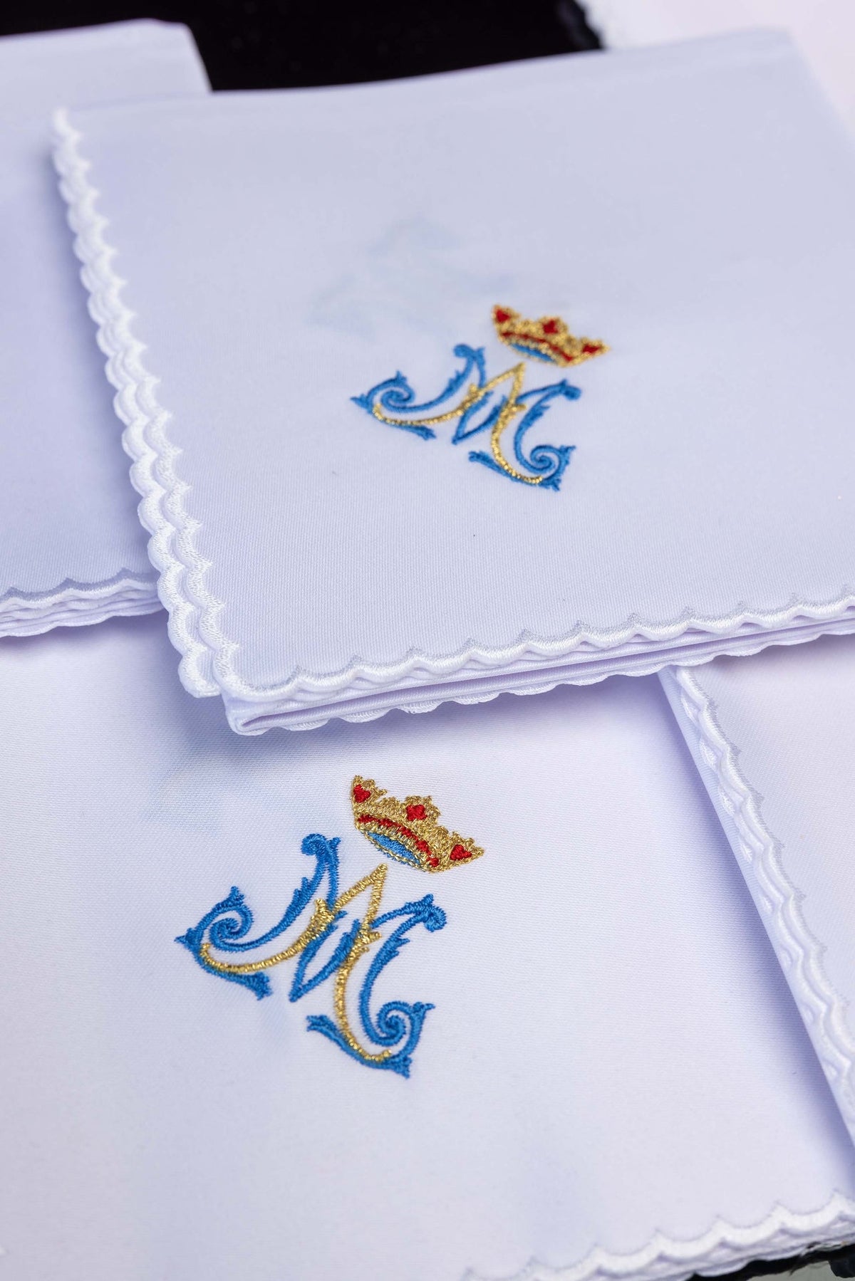 Folded view of the corporal set with white scalloped edges and blue and gold Marian embroidery