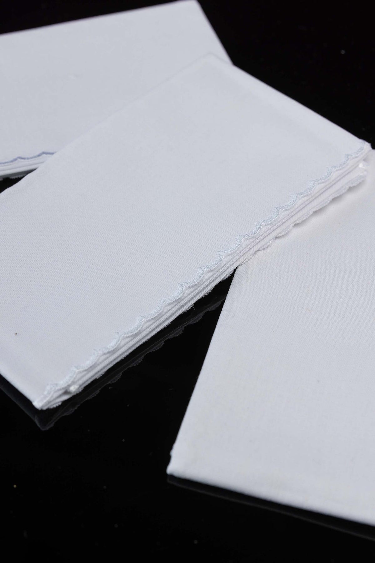 Close-up of the white lavabo towel set showing wavy trim and woven cotton texture