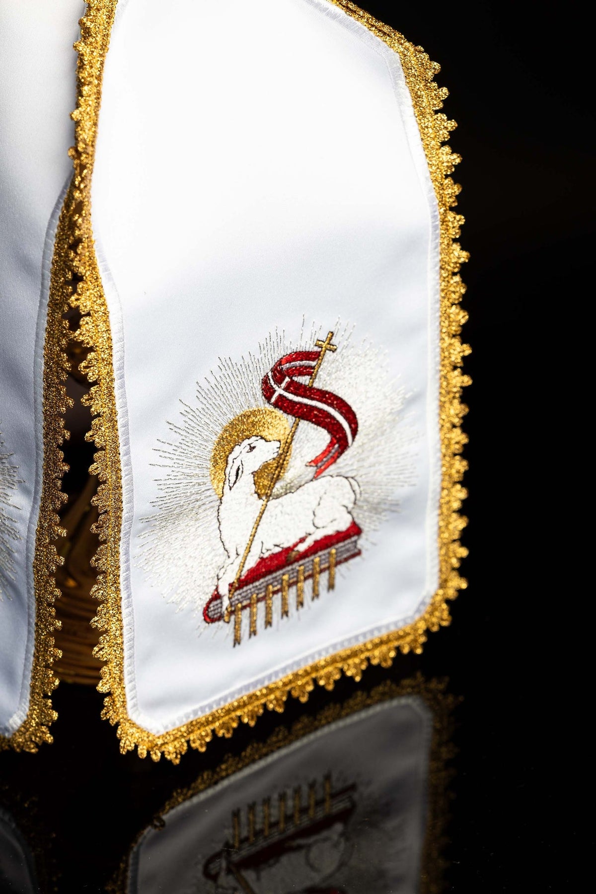 Angled view of the ciborium veil showing white fabric, gold edging and Paschal Lamb embroidery