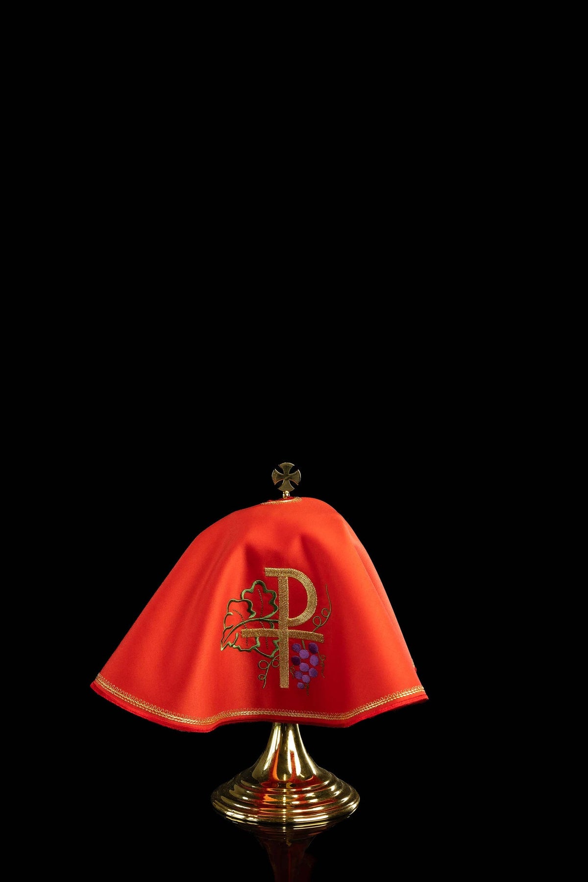 Front view of a red ciborium veil embroidered with gold PAX, grapes and leaves