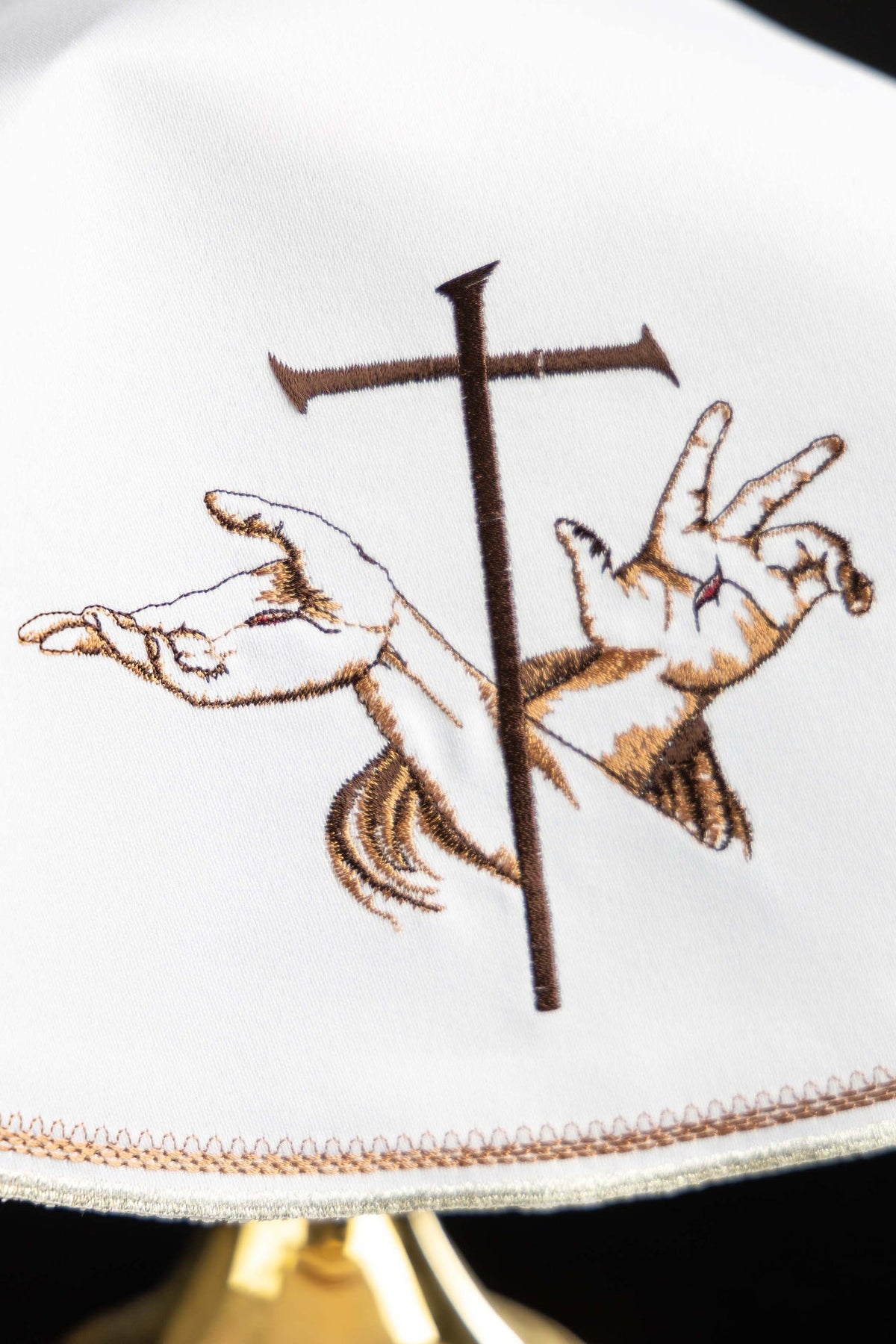 Close-up of ciborium veil embroidery showing a Franciscan motif and cross