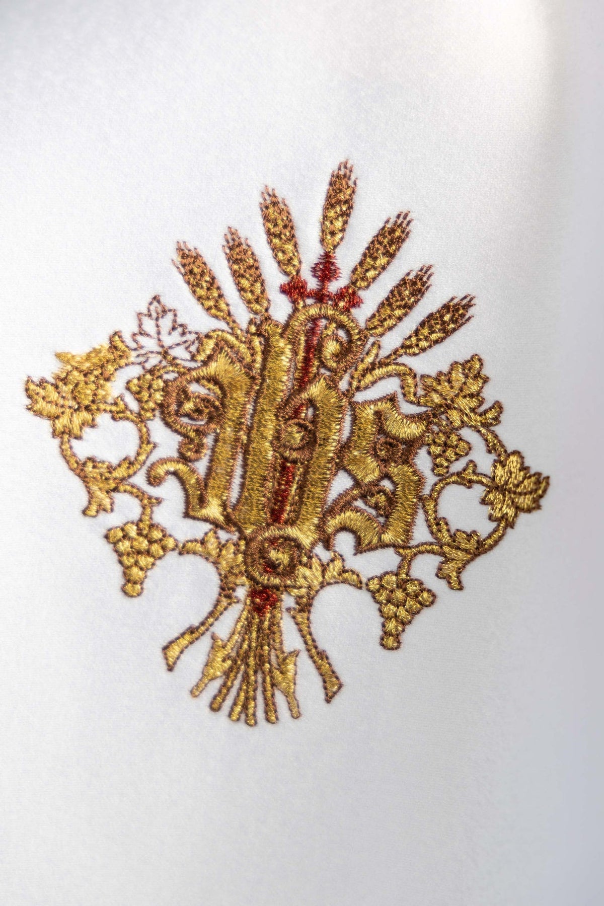 Close-up of IHS embroidery on the white ciborium veil
