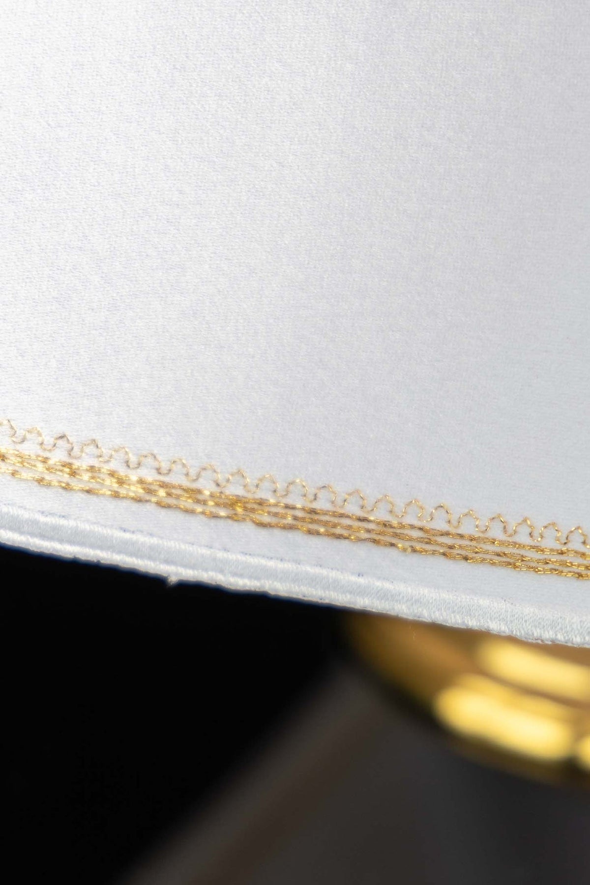 Close-up of gold embroidered edging on the white ciborium veil