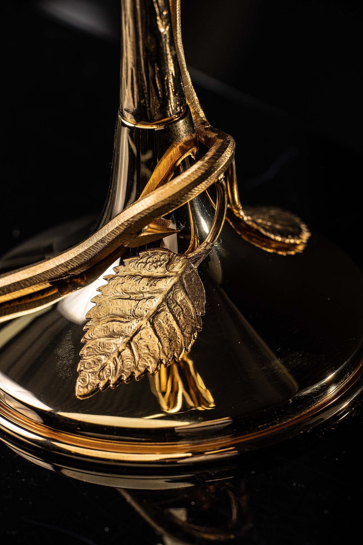 Base detail of the reliquary showing a textured gold leaf ornament and curved support