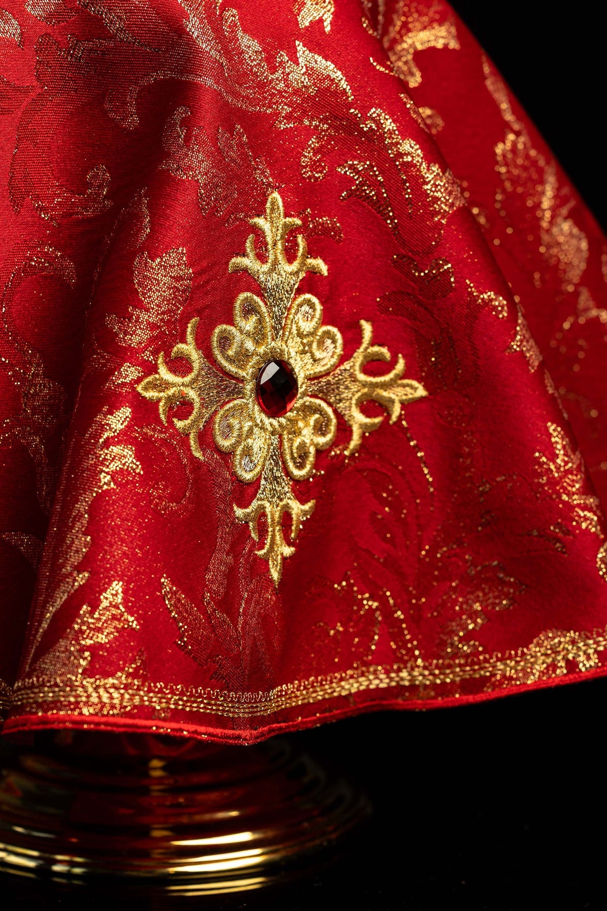 Close-up of the embroidered cross and red stone on the red ciborium veil