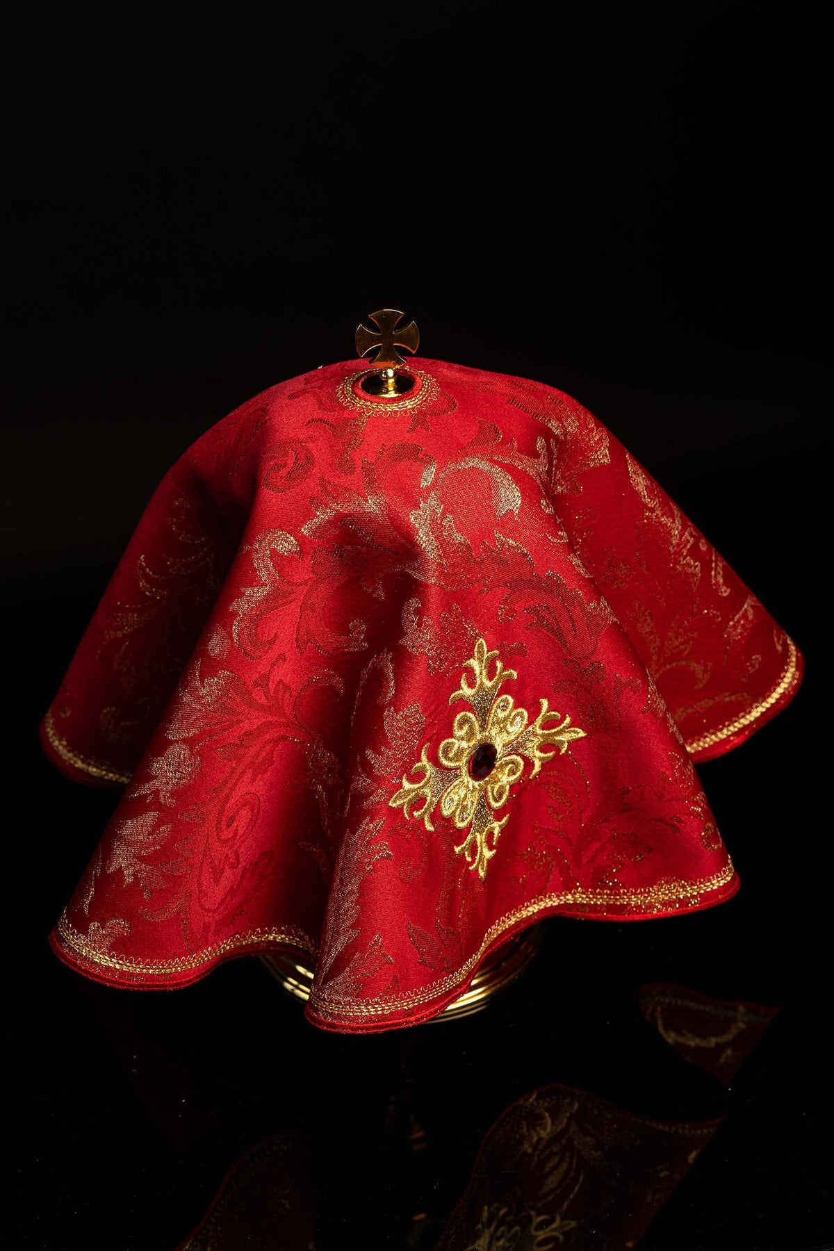 Back view of the red ciborium veil with gold embroidery and cross finial