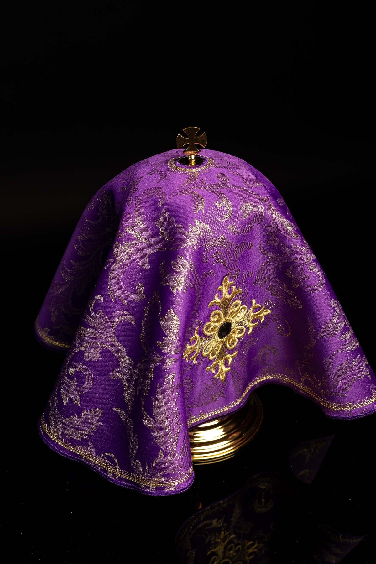 Angled view of the purple ciborium veil with embroidered cross, stone, and gold trim