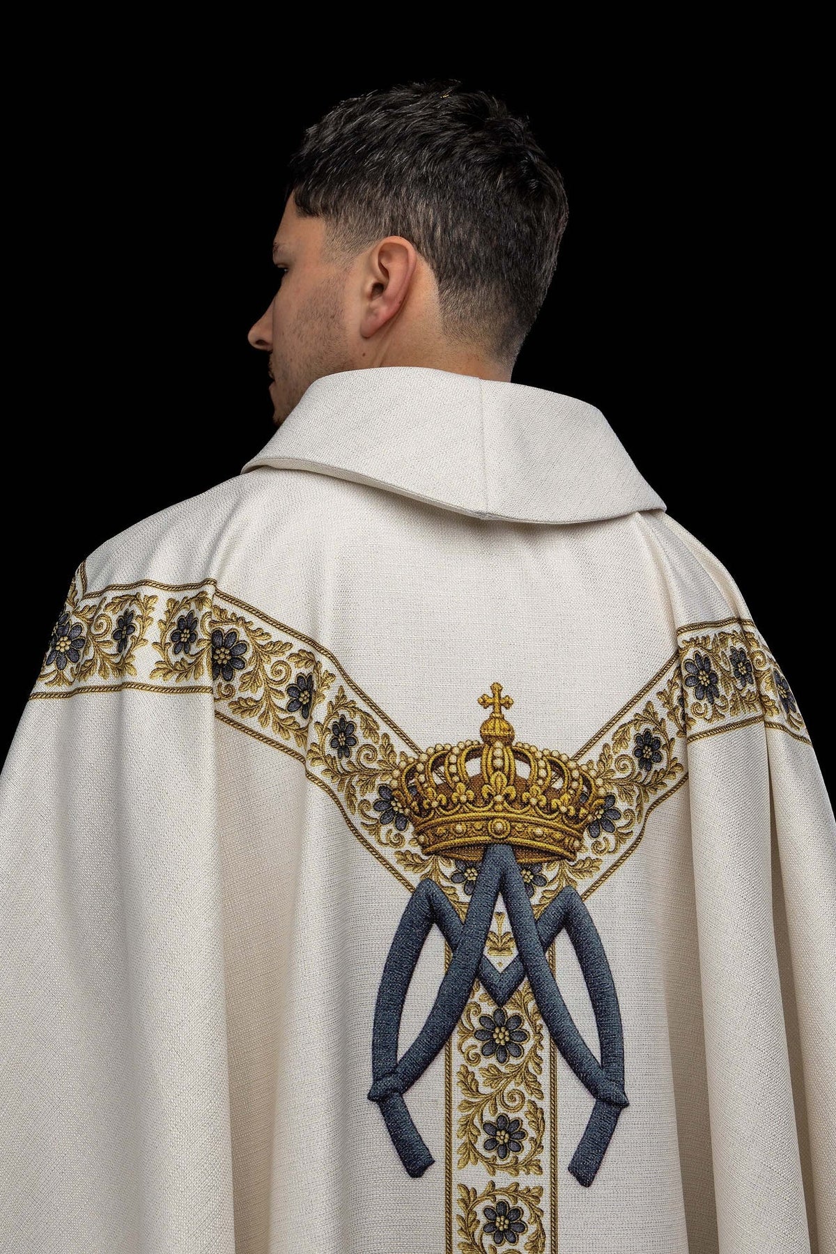 Back view of the chasuble with a crown, blue ribbons, and floral orphrey