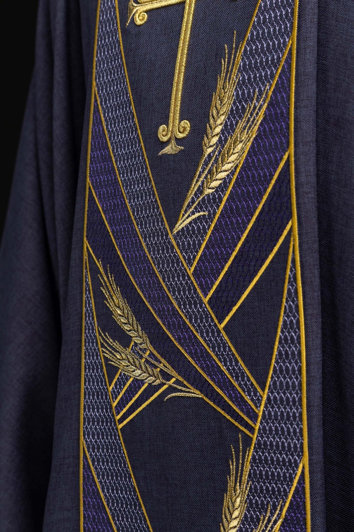 Detail view of the embroidered Pax band with gold cross, wheat, and geometric purple patterns
