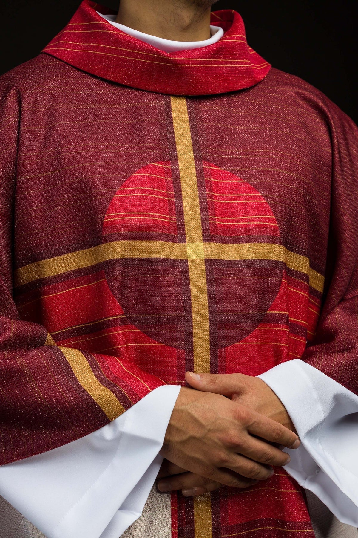 Front close-up of the red chasuble with circular cross motif and gold center bands