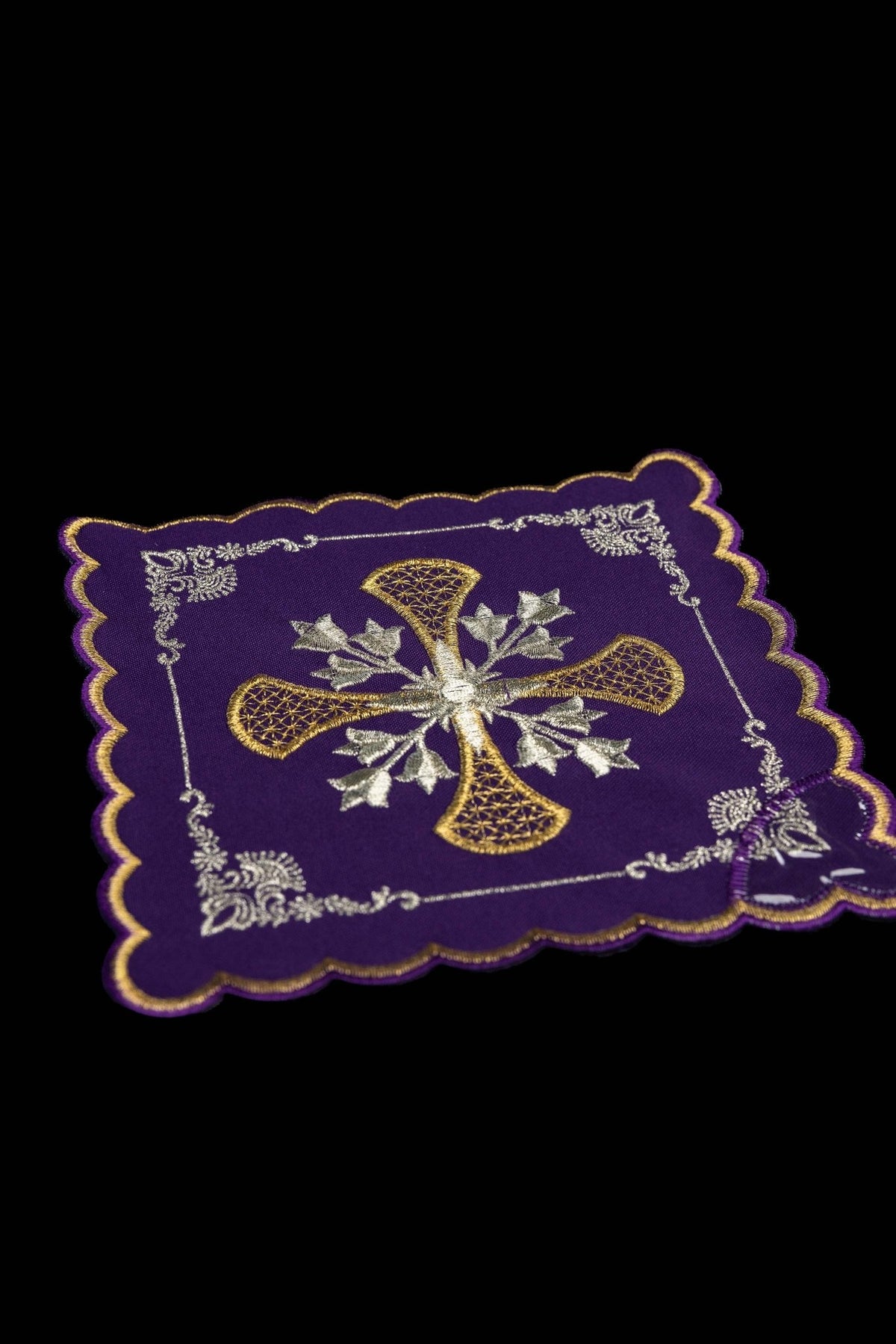Angled view of purple chalice pall with gold and silver embroidered cross