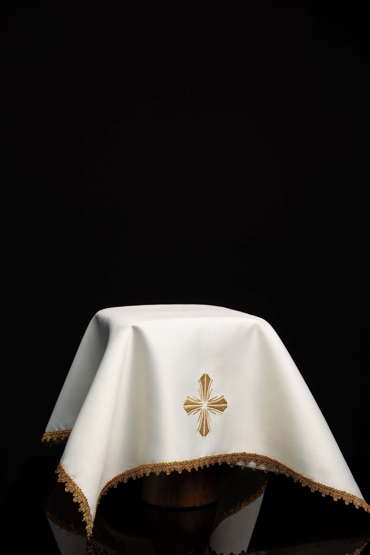 Worn white chalice veil with gold cross embroidery and scalloped trim
