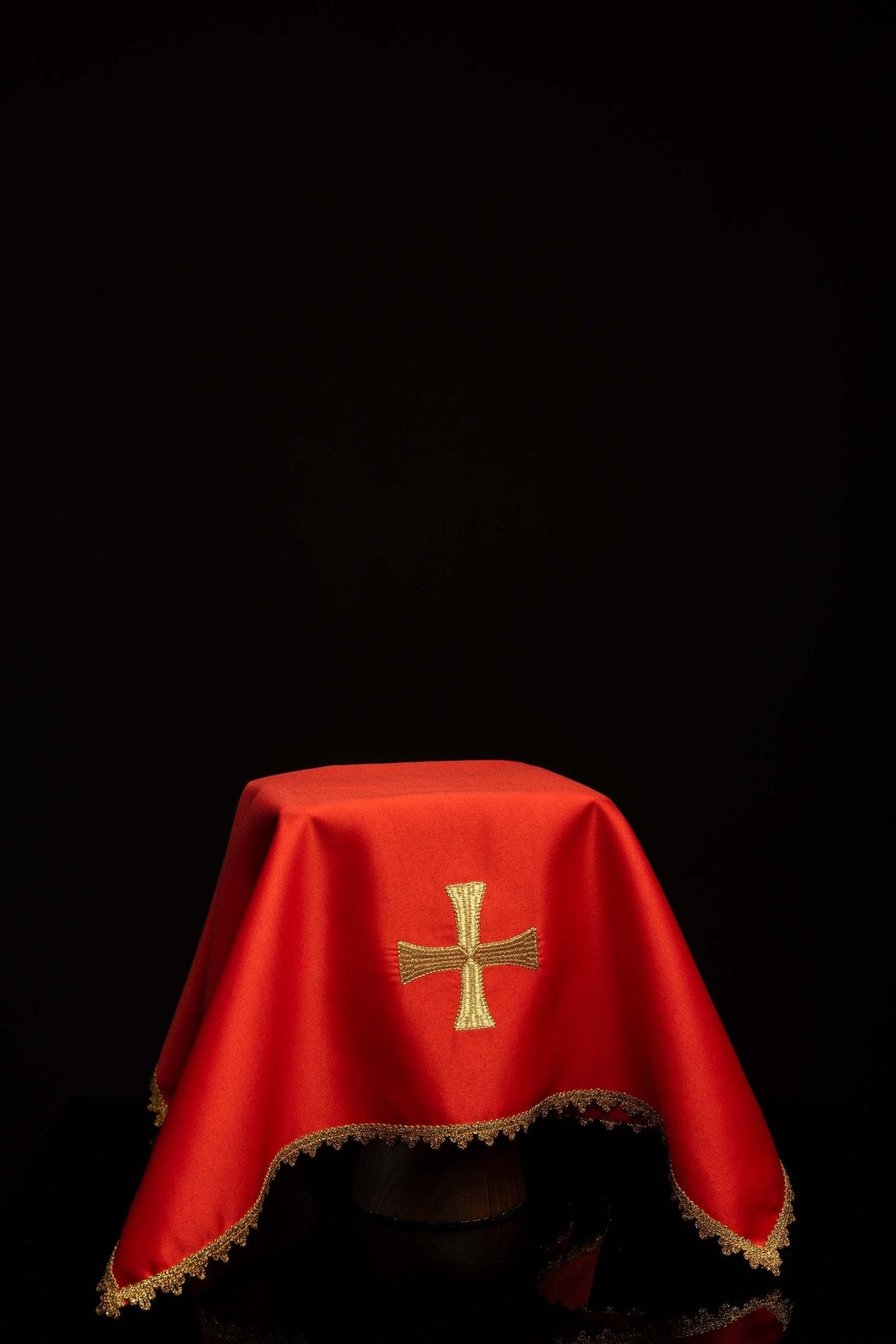 Worn red chalice veil with gold cross embroidery and scalloped gold trim