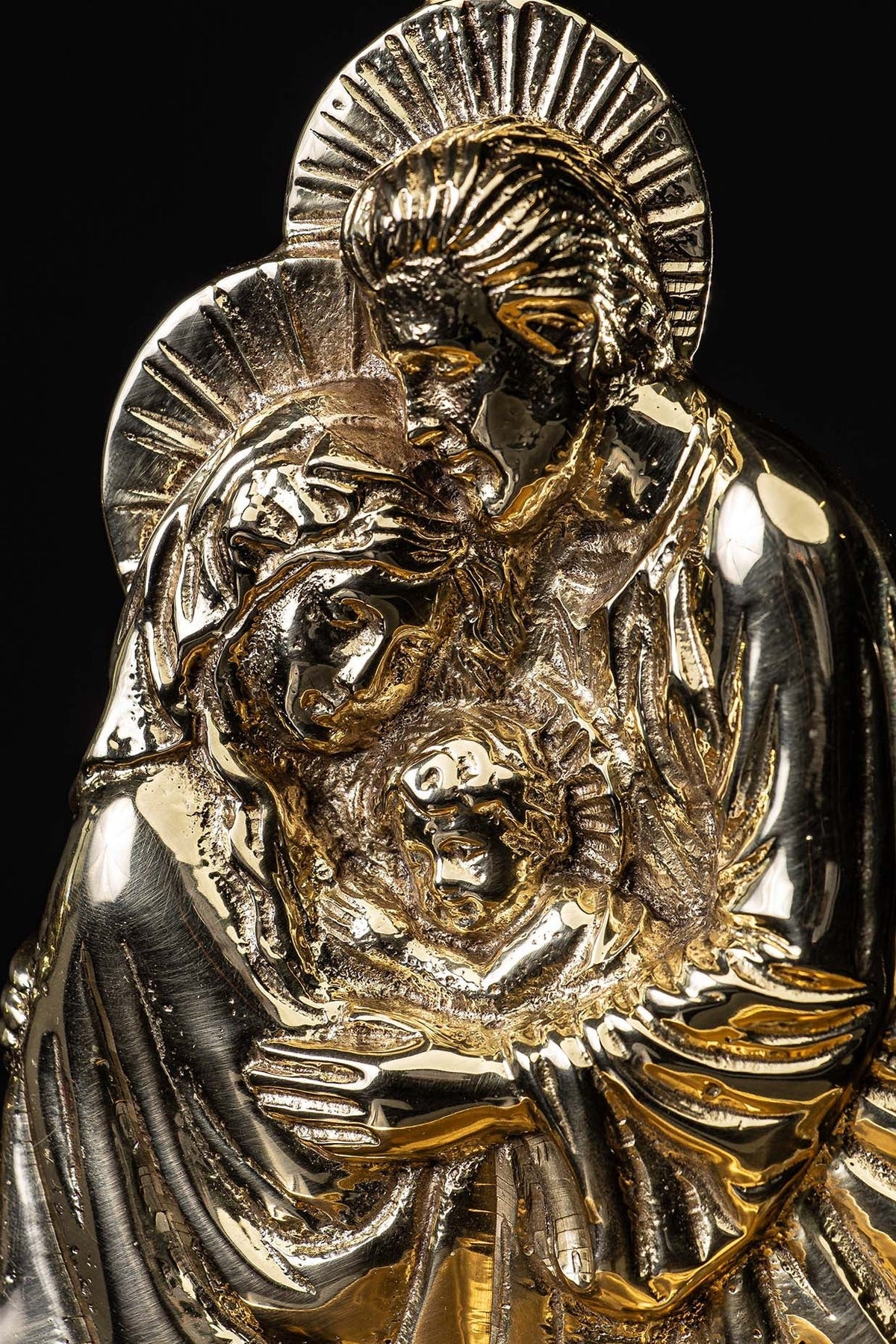 Detail of Holy Family motif on brass holy water font with textured robes and halos
