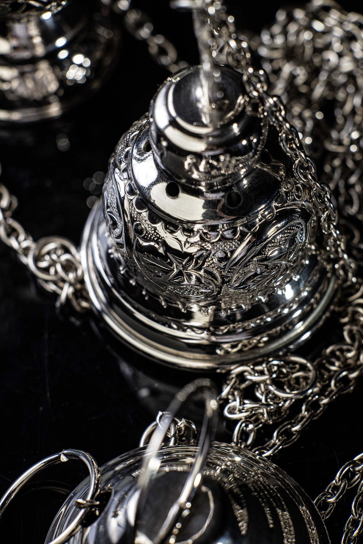 Detail view of the thurible cross finial and decorated nickel-plated lid