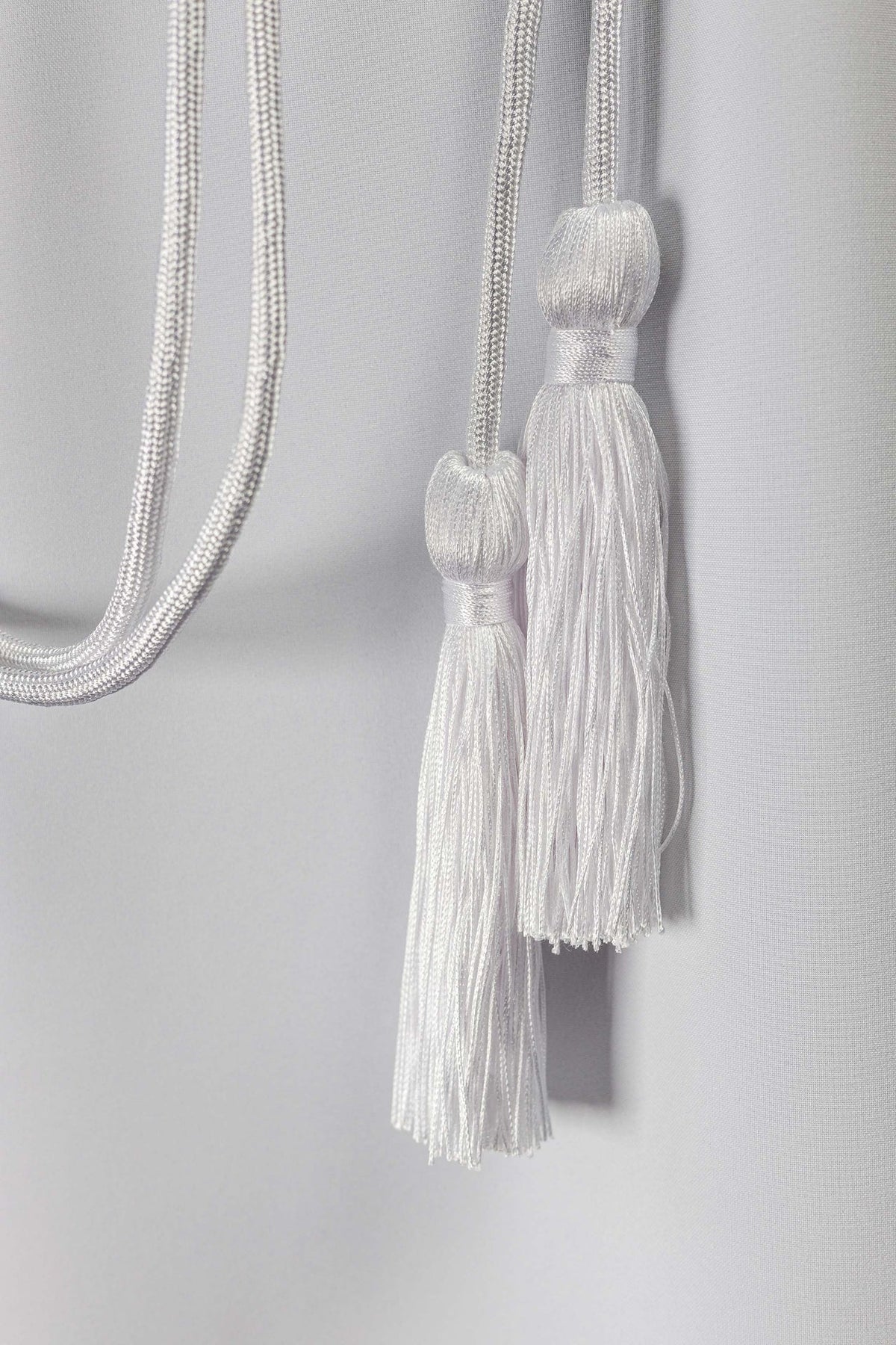 Close-up of the white liturgical cincture with two tassels