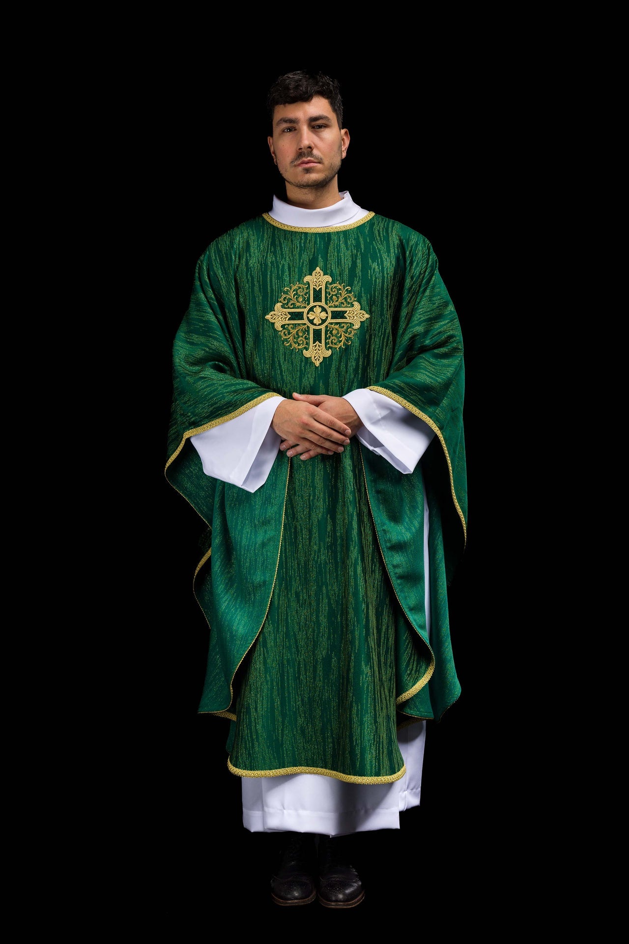 Green chasuble with embroidered cross motif on decorative fabric
