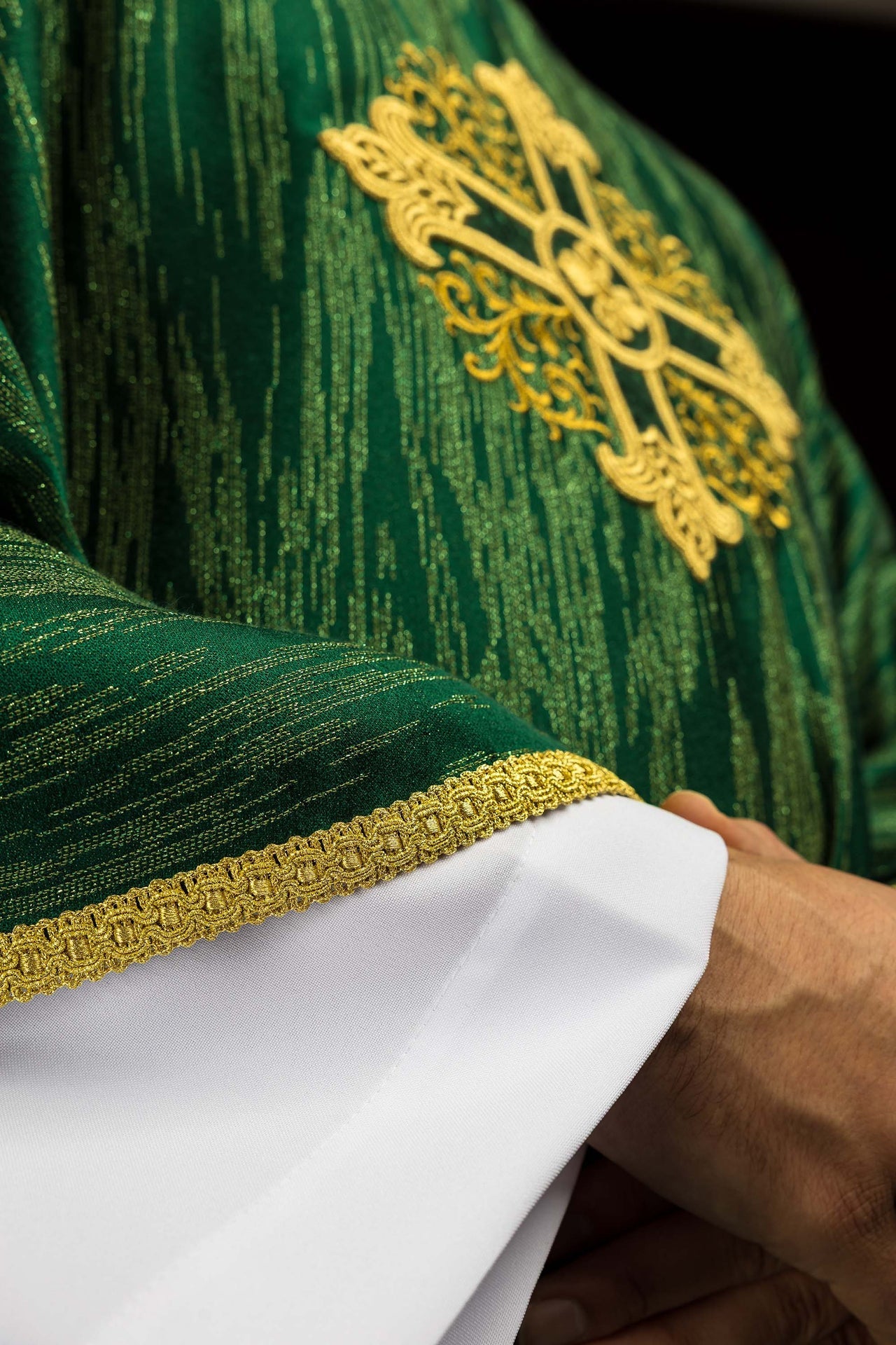 Green chasuble with embroidered cross motif on decorative fabric