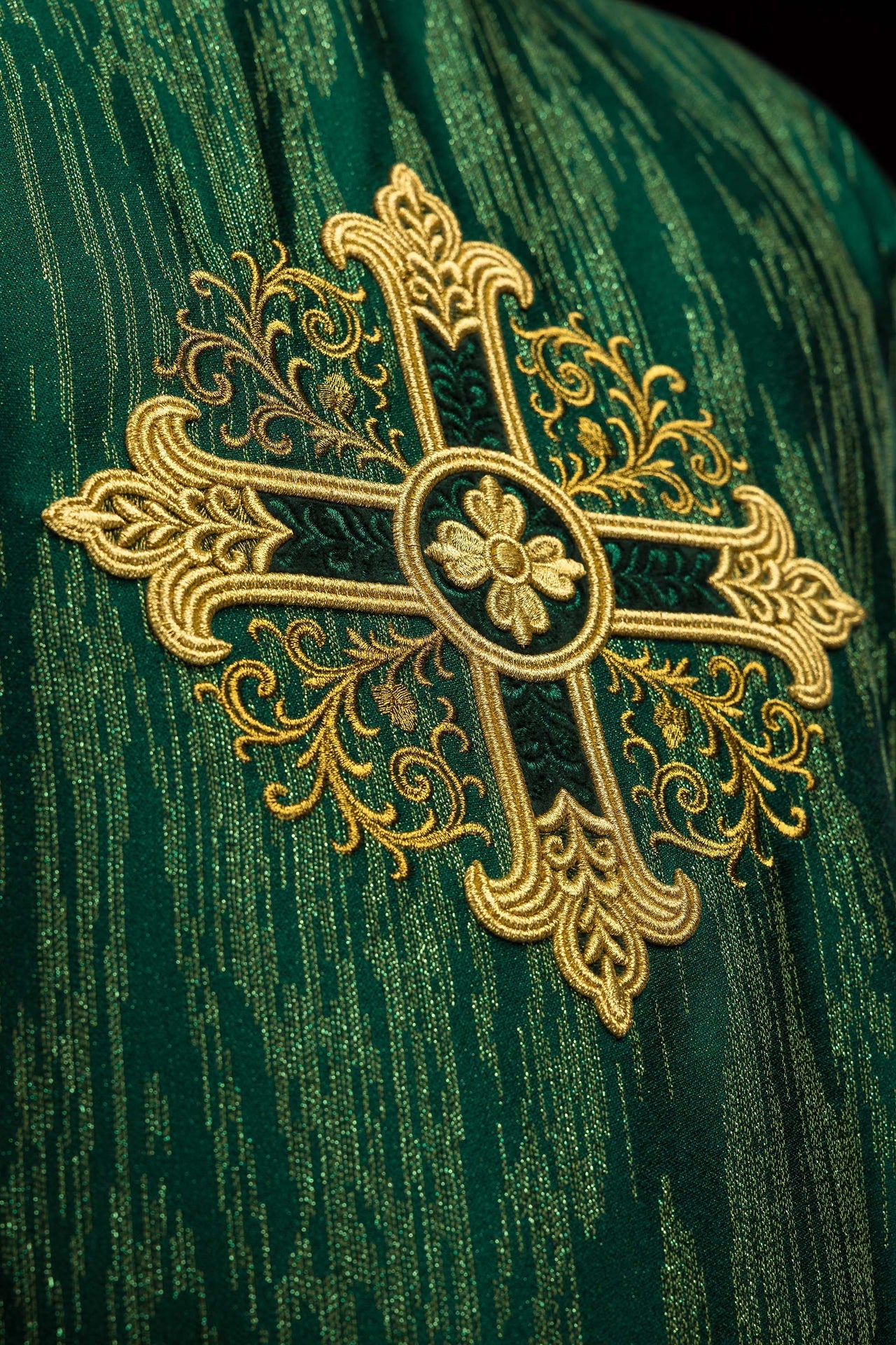 Green chasuble with embroidered cross motif on decorative fabric