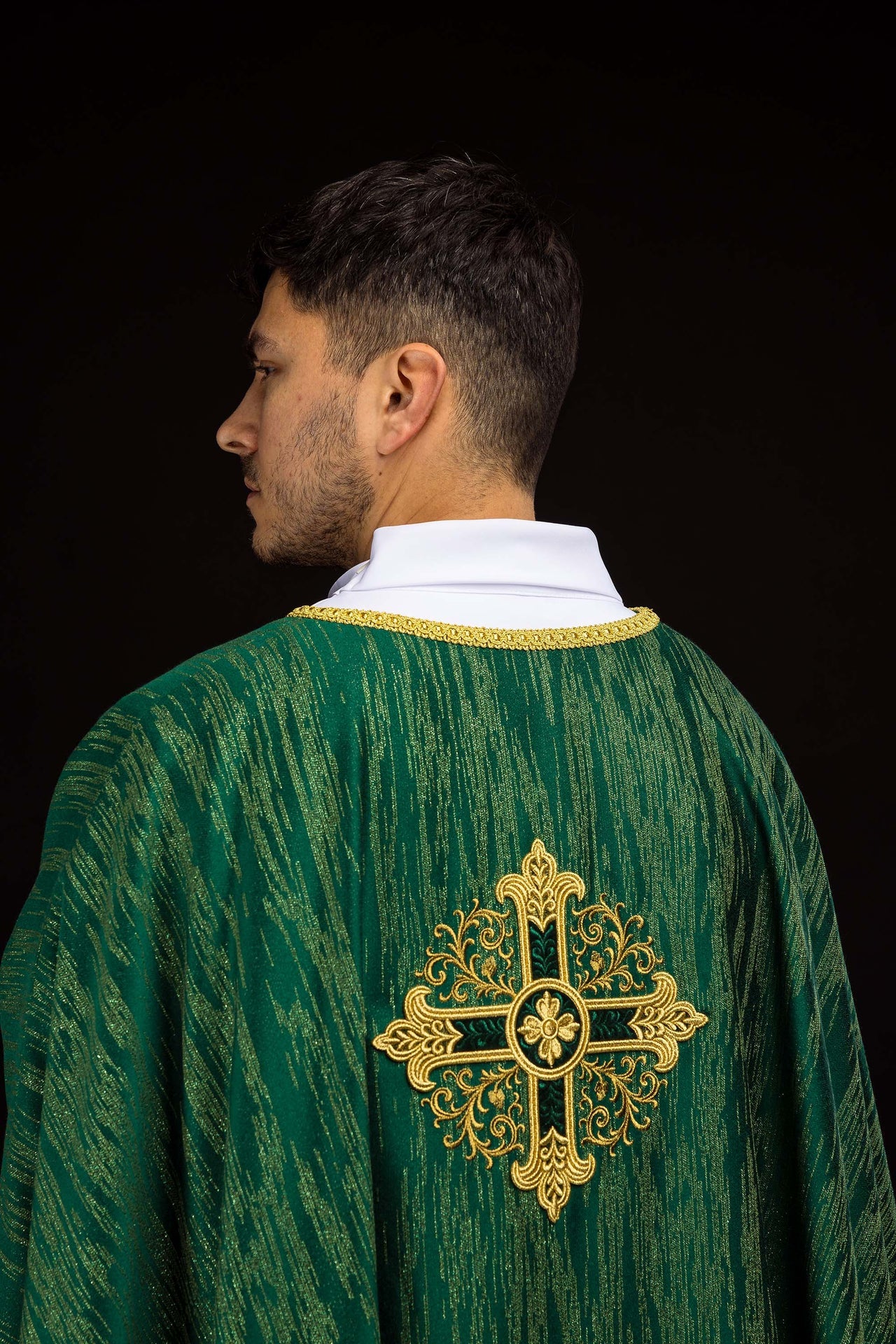 Green chasuble with embroidered cross motif on decorative fabric