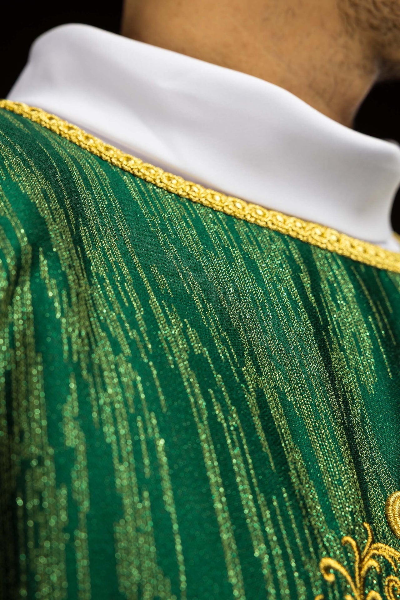 Green chasuble with embroidered cross motif on decorative fabric